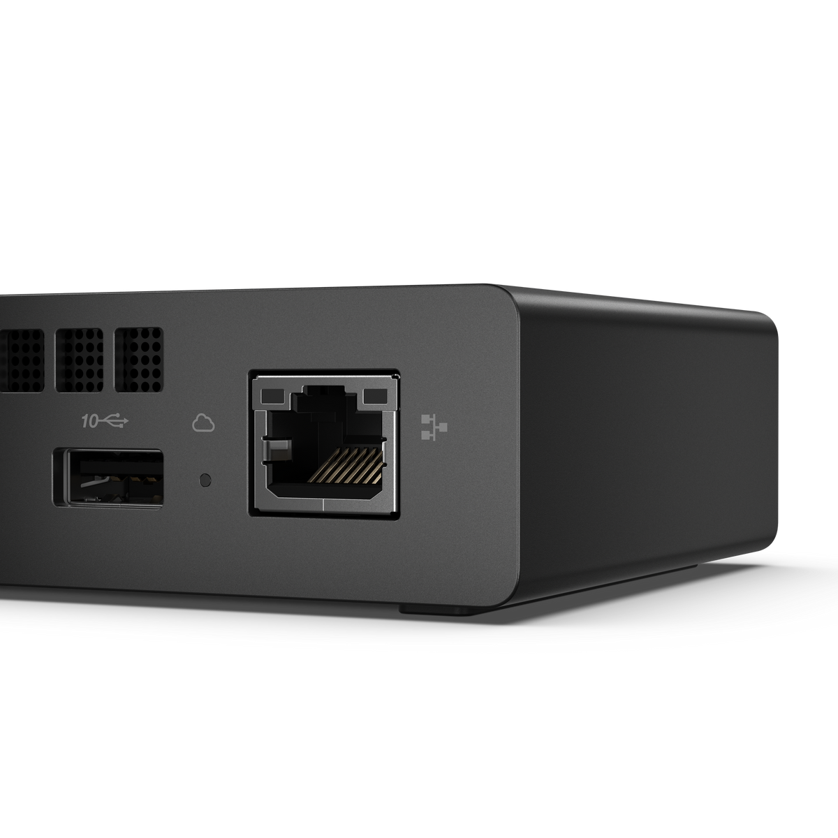Primo piano di un dispositivo informatico nero con porte USB, Ethernet e di ventilazione.