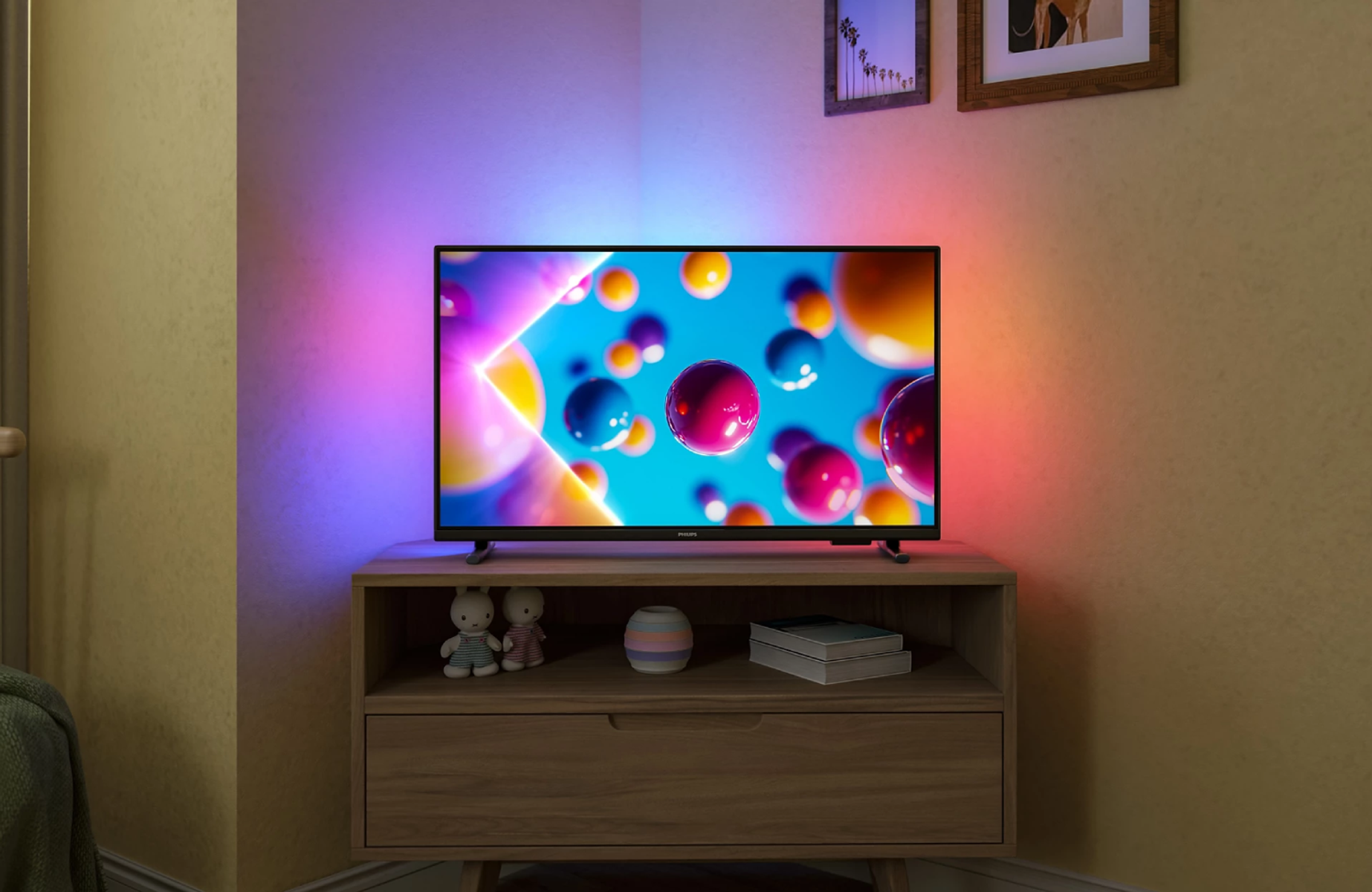 Nowoczesny telewizor wyświetla kolorowe abstrakcyjne kule na niebieskim tle. Oświetlenie nastrojowe dodaje odcieni fioletu i różu.