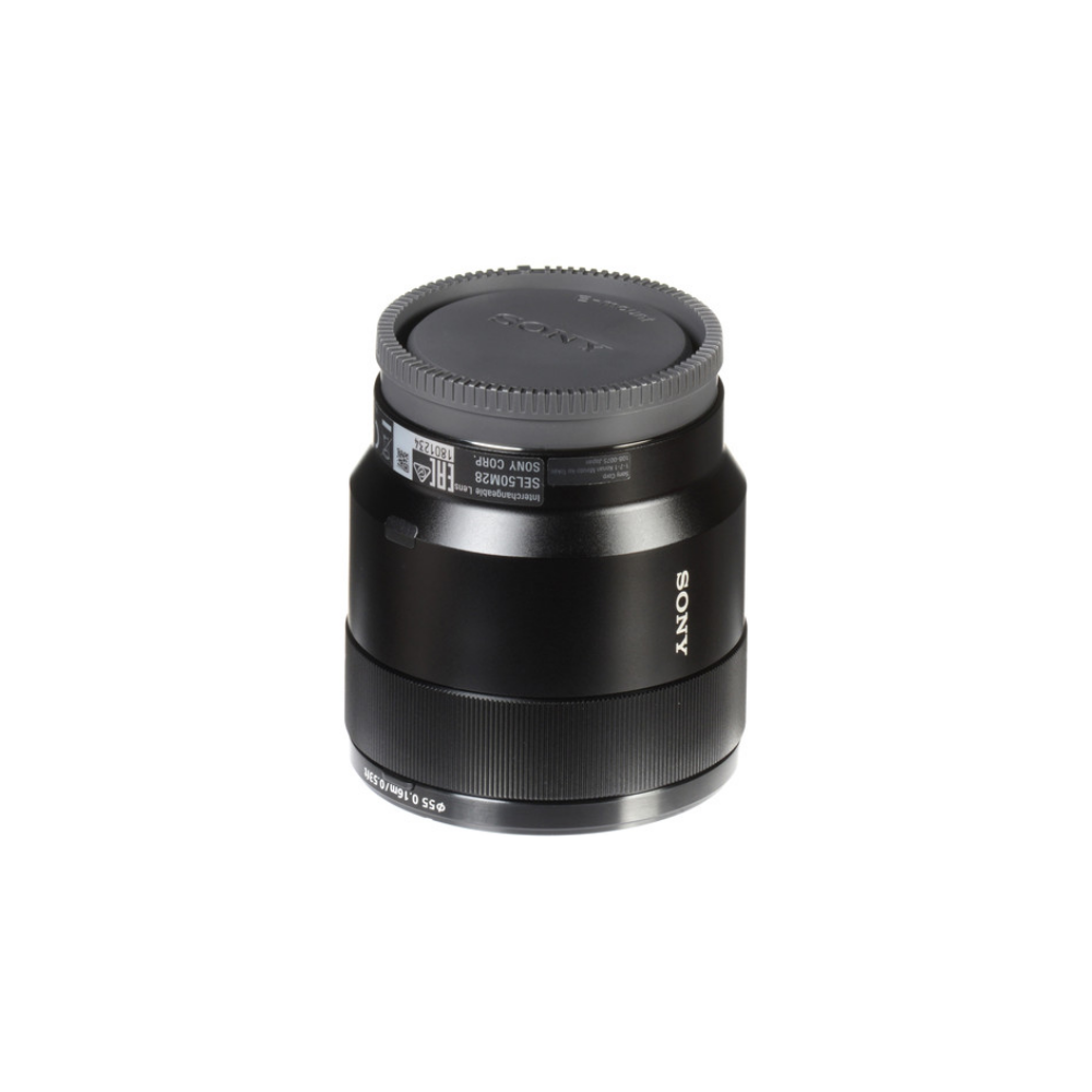 Un objetivo de cámara Sony SEL50M28 negro con tapa gris y etiquetado.