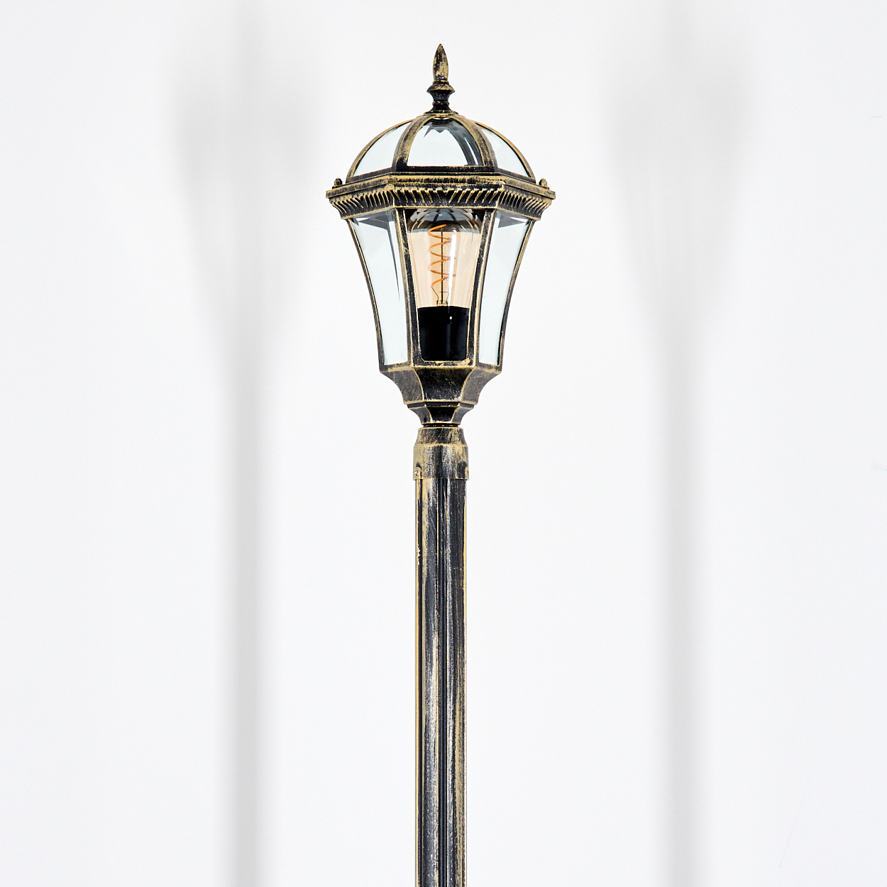 Eine dekorative Lampe mit Glaskuppel und sichtbarem Leuchtmittel.