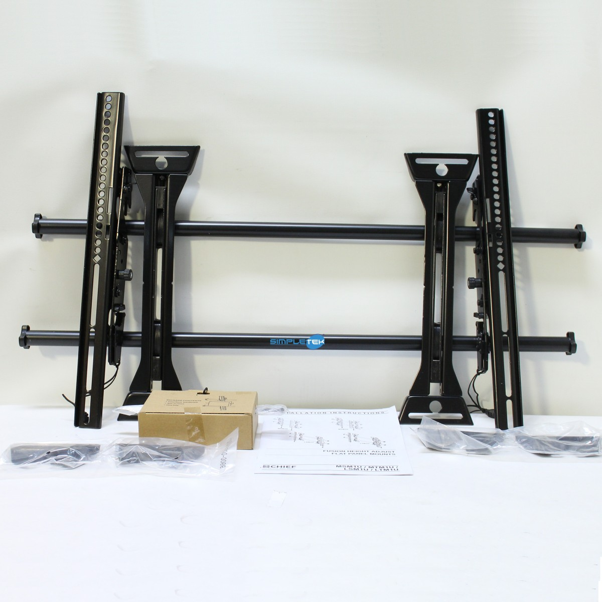 Soporte de pared para TV de metal negro con instrucciones y herrajes.