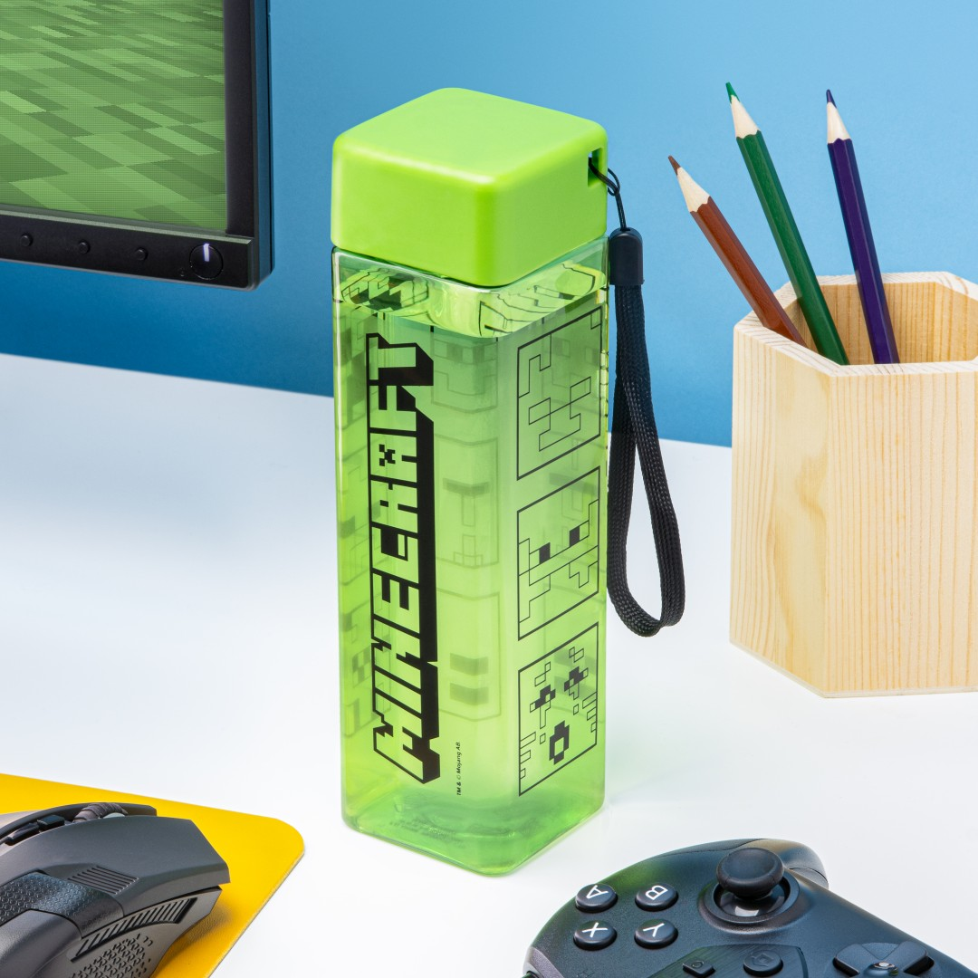 Zielona butelka Minecraft z akcesoriami do gier na biurku.