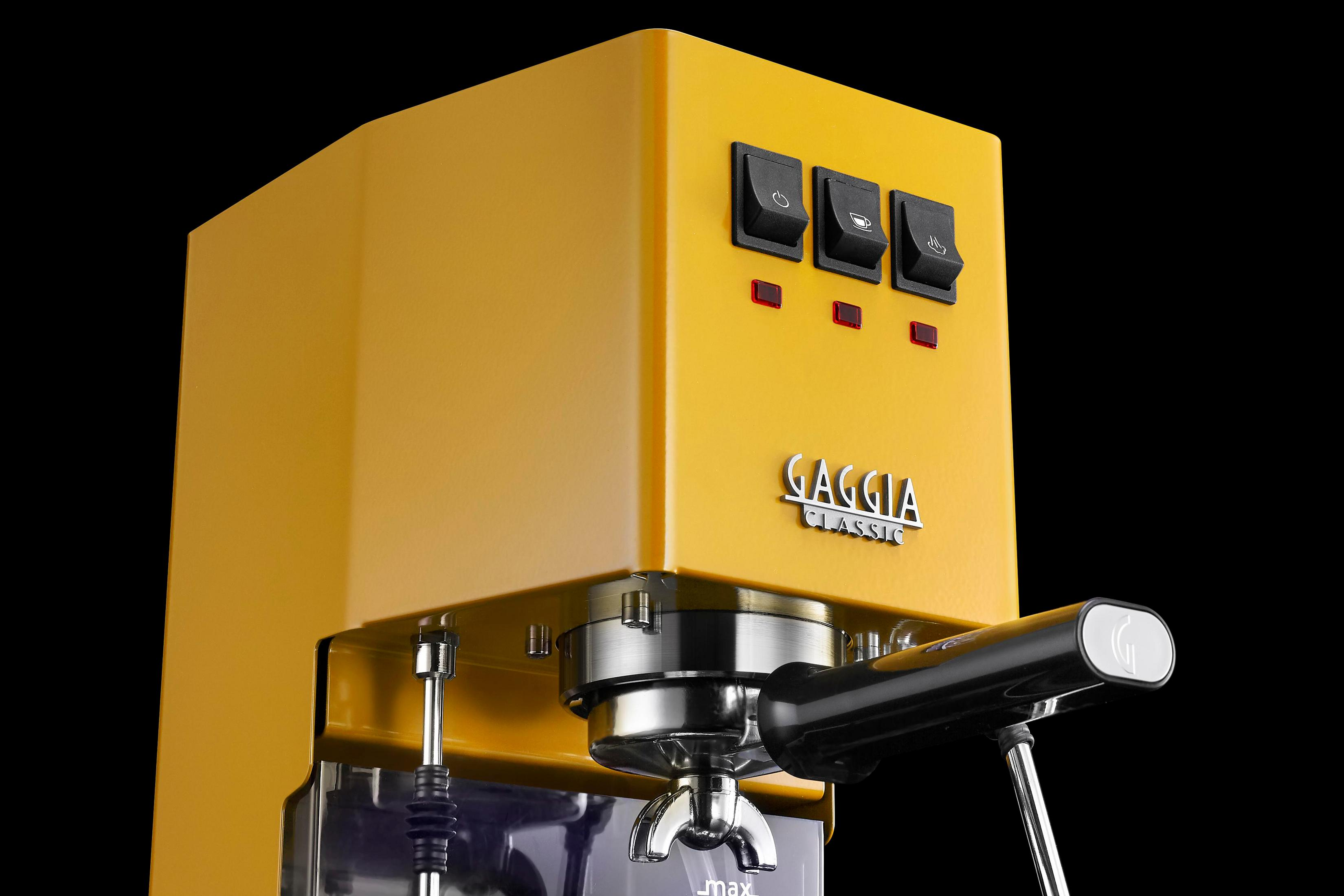 Gele espressomachine met zilveren en zwarte elementen, vooraanzicht.