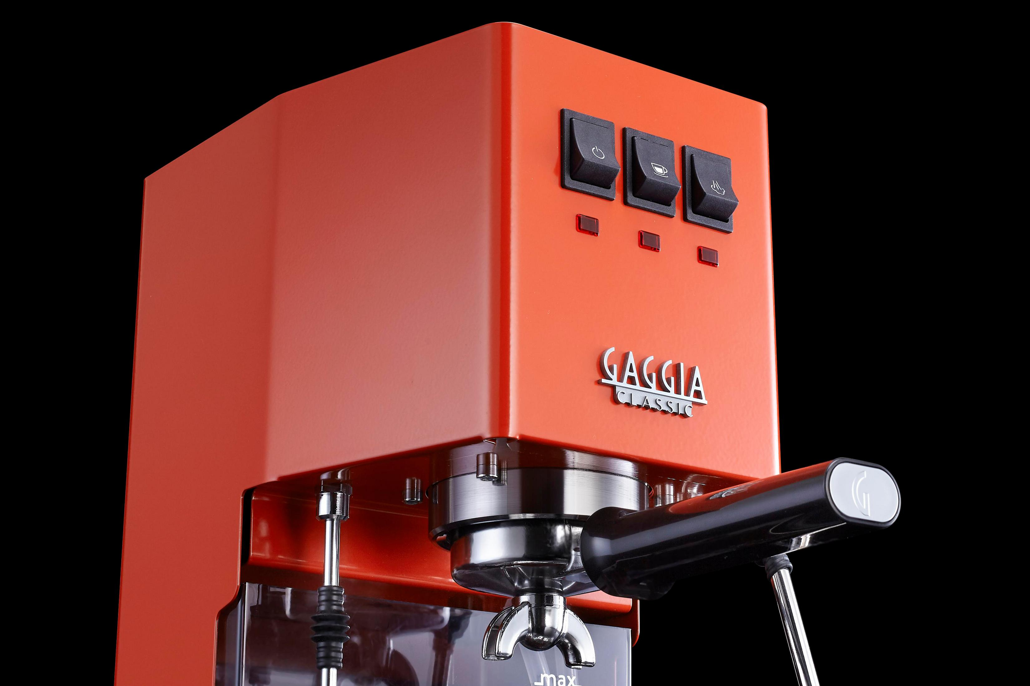 Een oranje espressomachine met drie schakelaars en het Gaggia-logo.