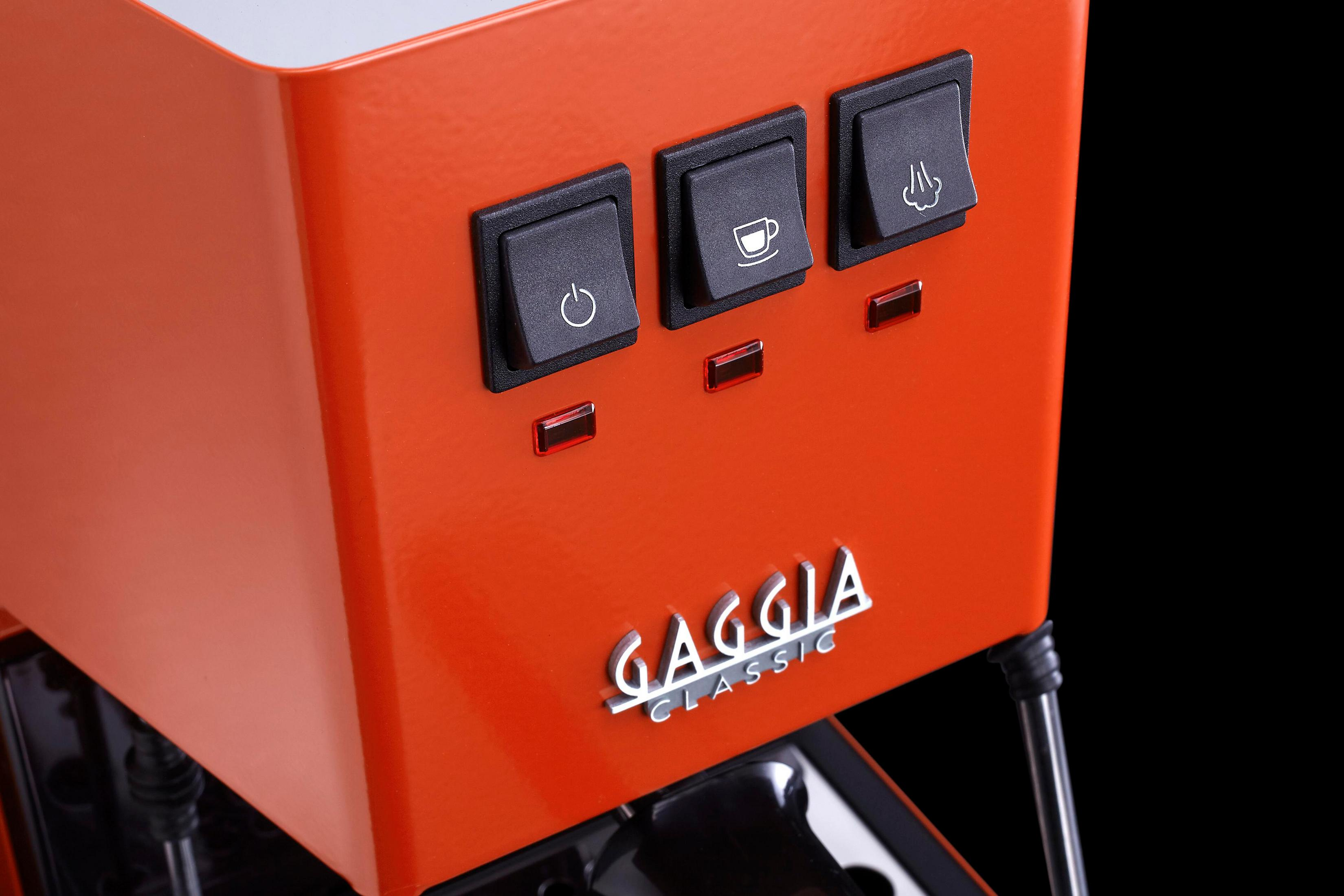 Oranje espressomachine met drie schakelaars en lampjes.