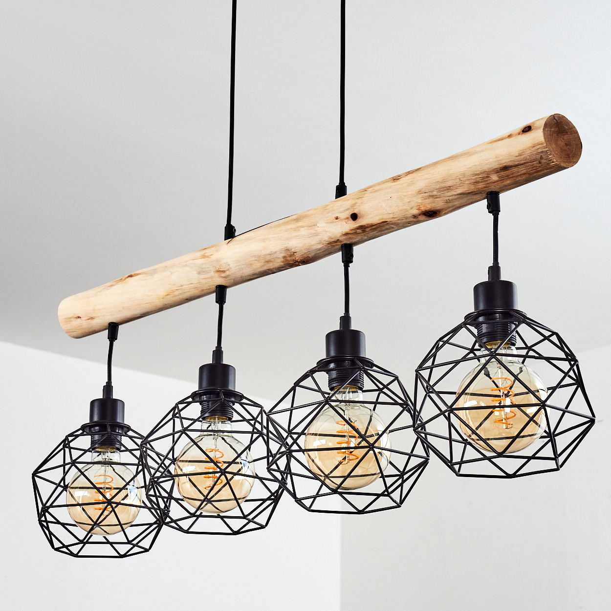 Ein rustikaler Kronleuchter mit einem Holzbalken und vier schwarzen geometrischen Käfigen mit Edison-Glühbirnen.