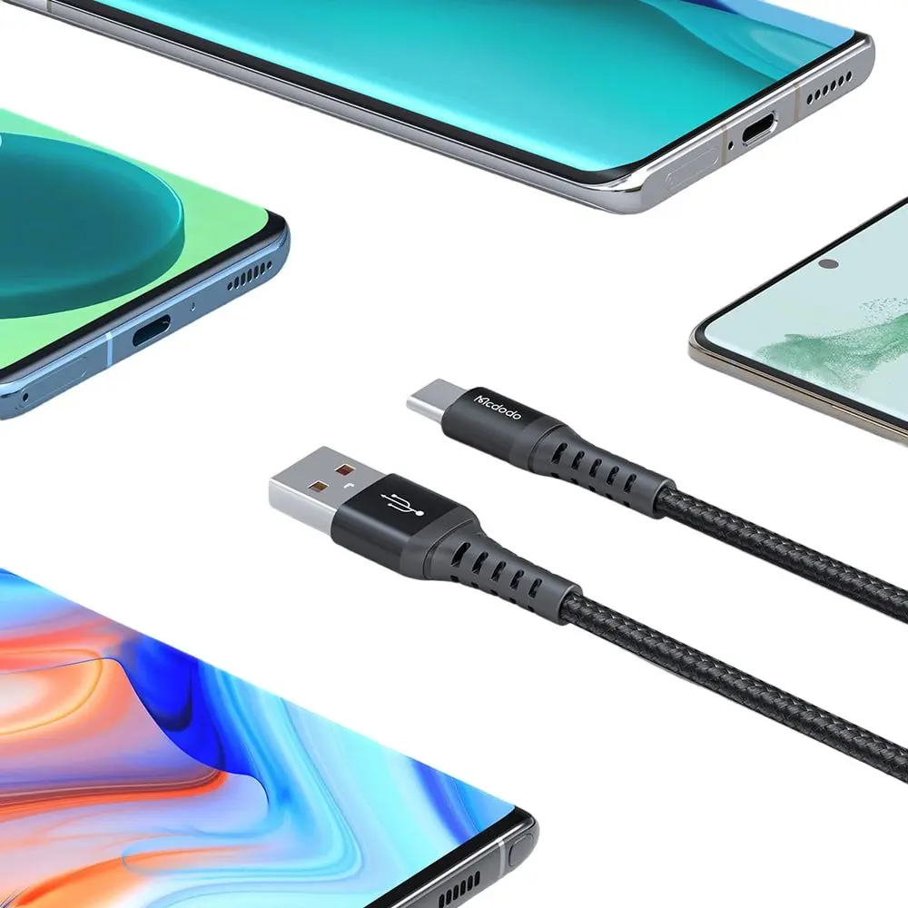 Gümüş USB-A konektörlü bir USB-C şarj kablosu birden fazla akıllı telefonun üzerinde duruyor.