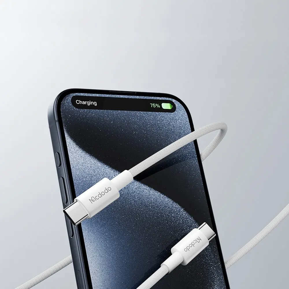USB-C konnektörlü beyaz şarj kablosu, %75 şarj gösteren bir akıllı telefona takılı.