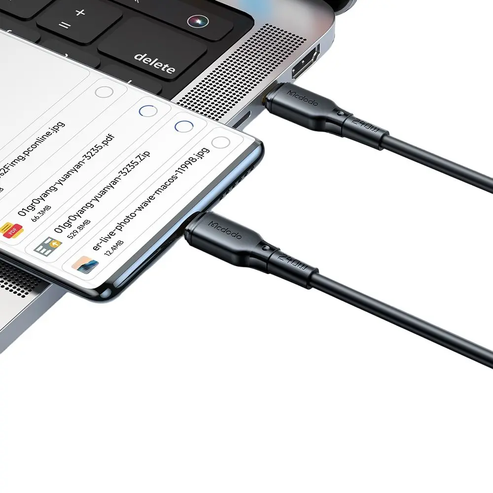 İki siyah şarj kablosu bir akıllı telefonu bir dizüstü bilgisayara bağlıyor.