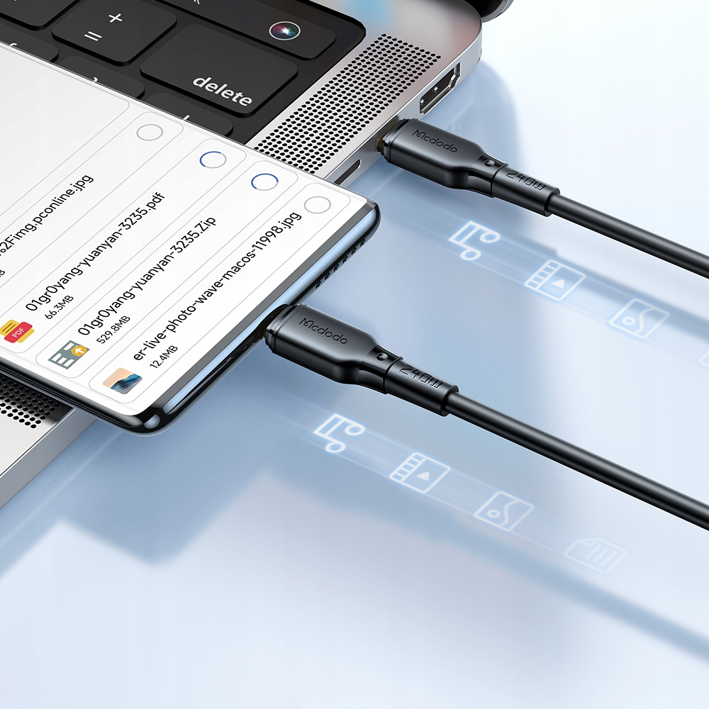 Bir akıllı telefon, iki siyah Mcdodo kablosu aracılığıyla bir dizüstü bilgisayara bağlıdır.