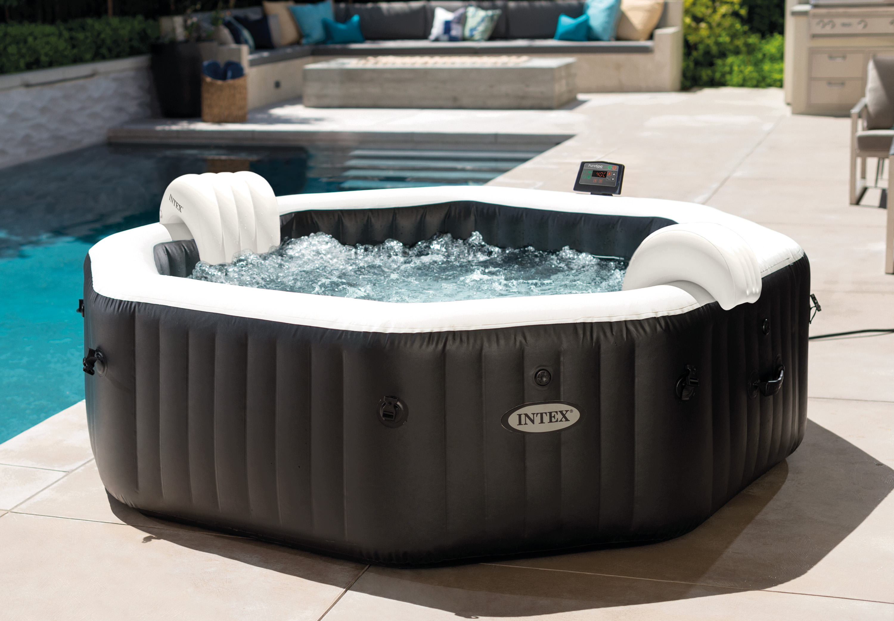 Ein aufblasbarer Whirlpool mit sprudelndem Wasser neben einem Pool.
