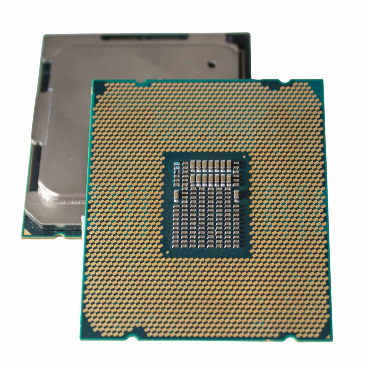 Un processore di computer con pin dorati e coperchio argentato su sfondo bianco.