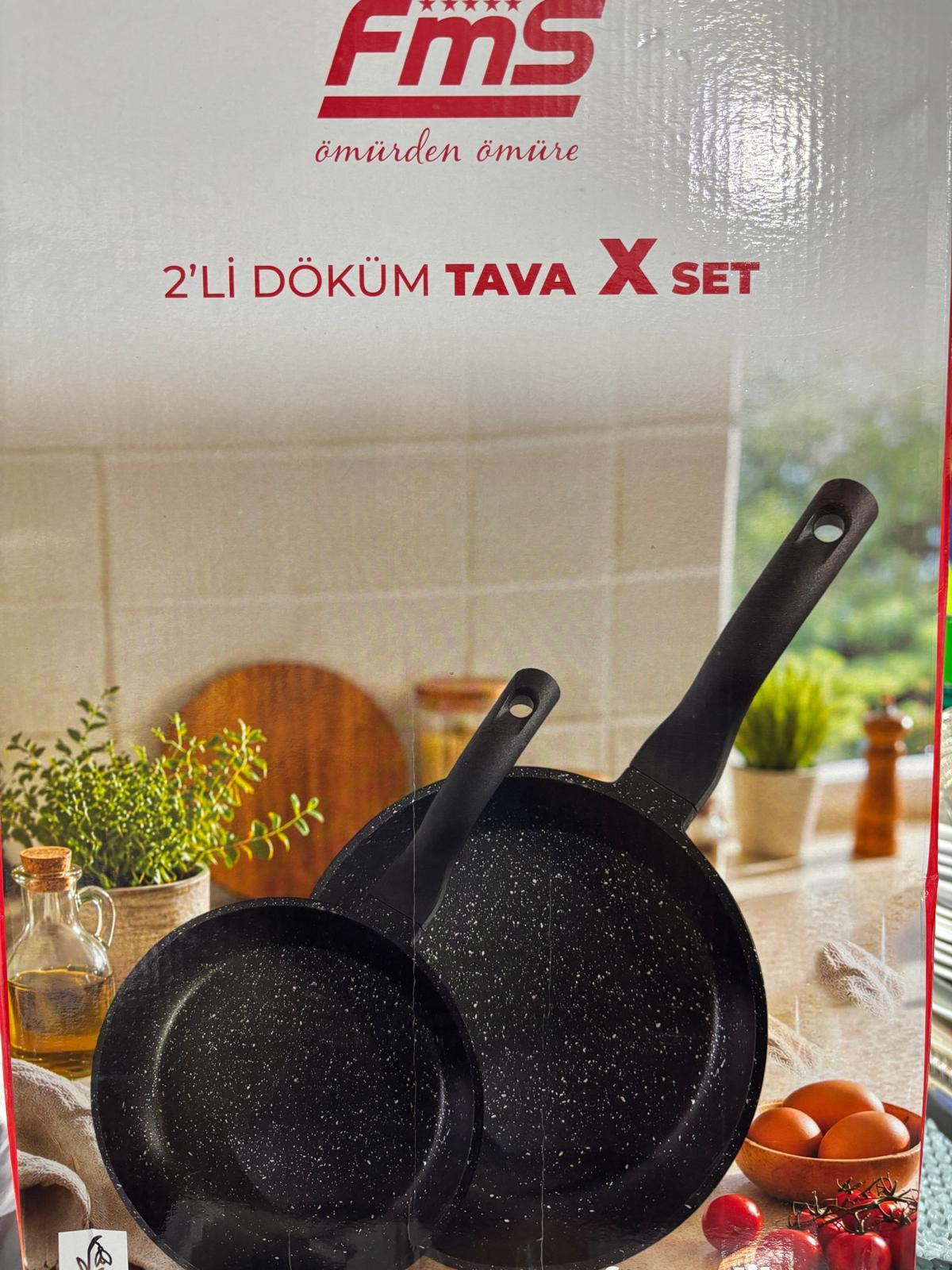 Mutfak tezgahı üzerinde beyaz benekli iki siyah tava seti.