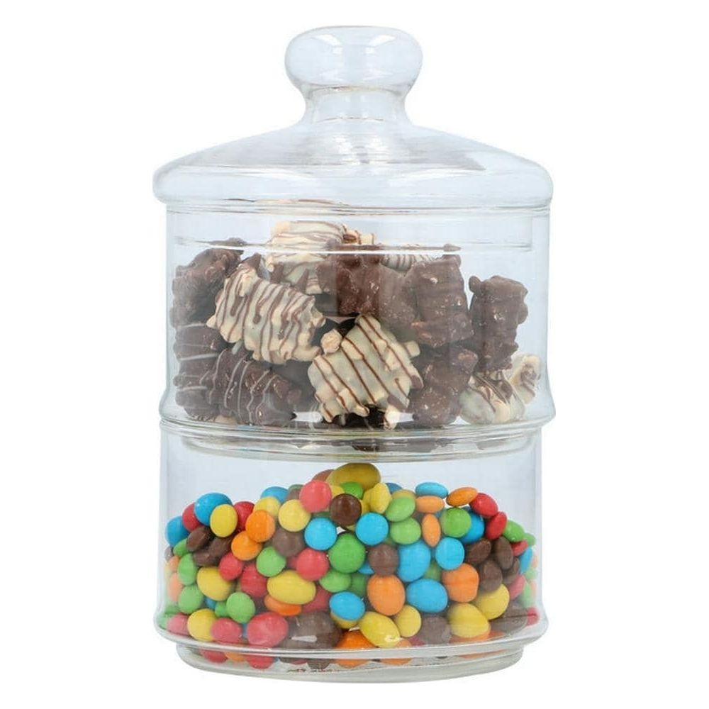 Two-tiered glass jar filled with chocolate cookies and colorful candies.