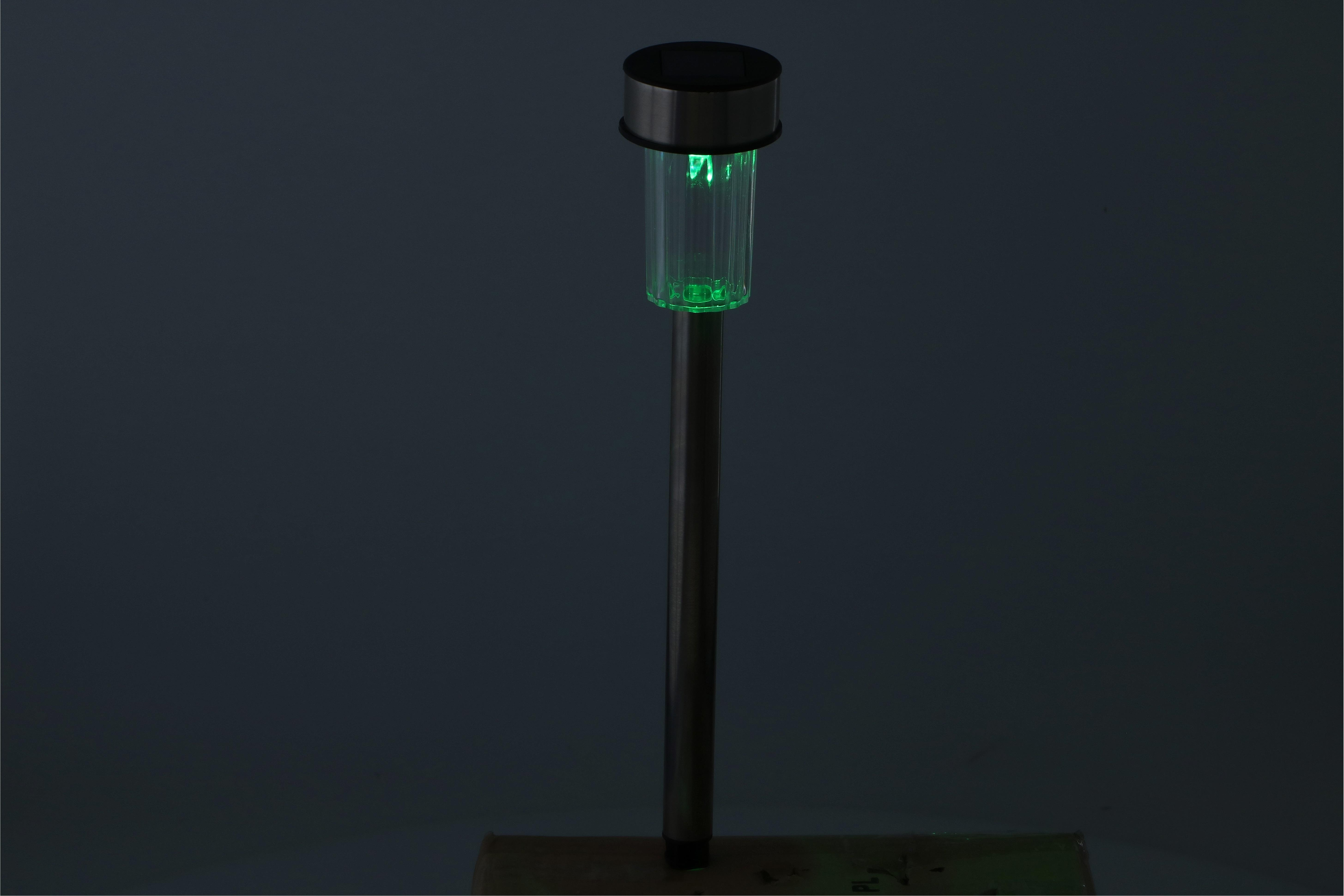 Een groene LED solar tuinlamp op een donkere achtergrond.