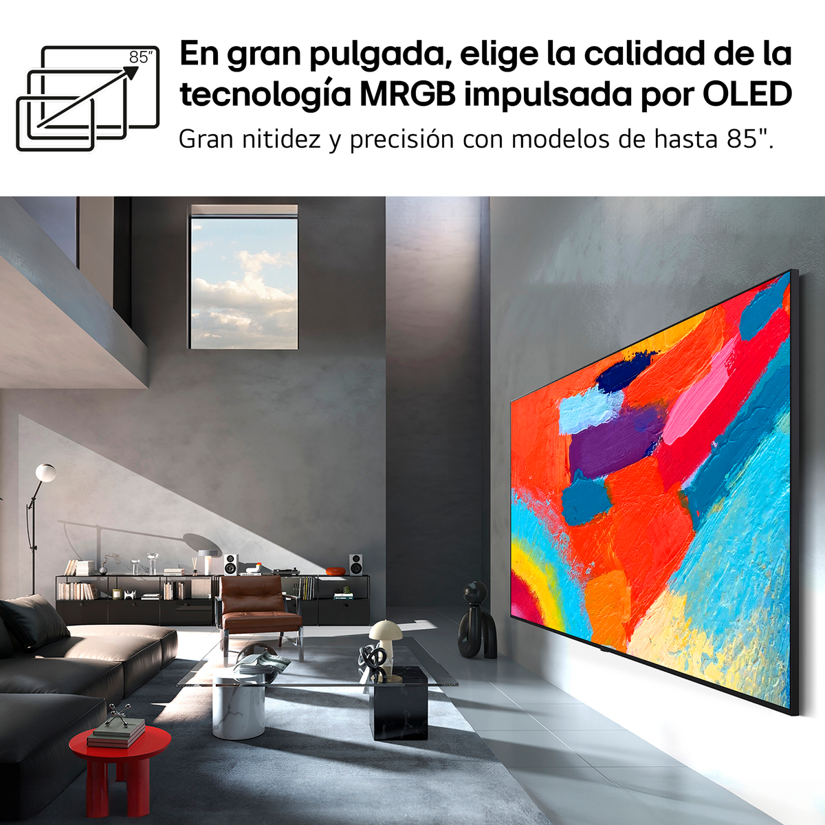 Una sala de estar moderna con un sofá grande, sillón y un enorme televisor OLED.