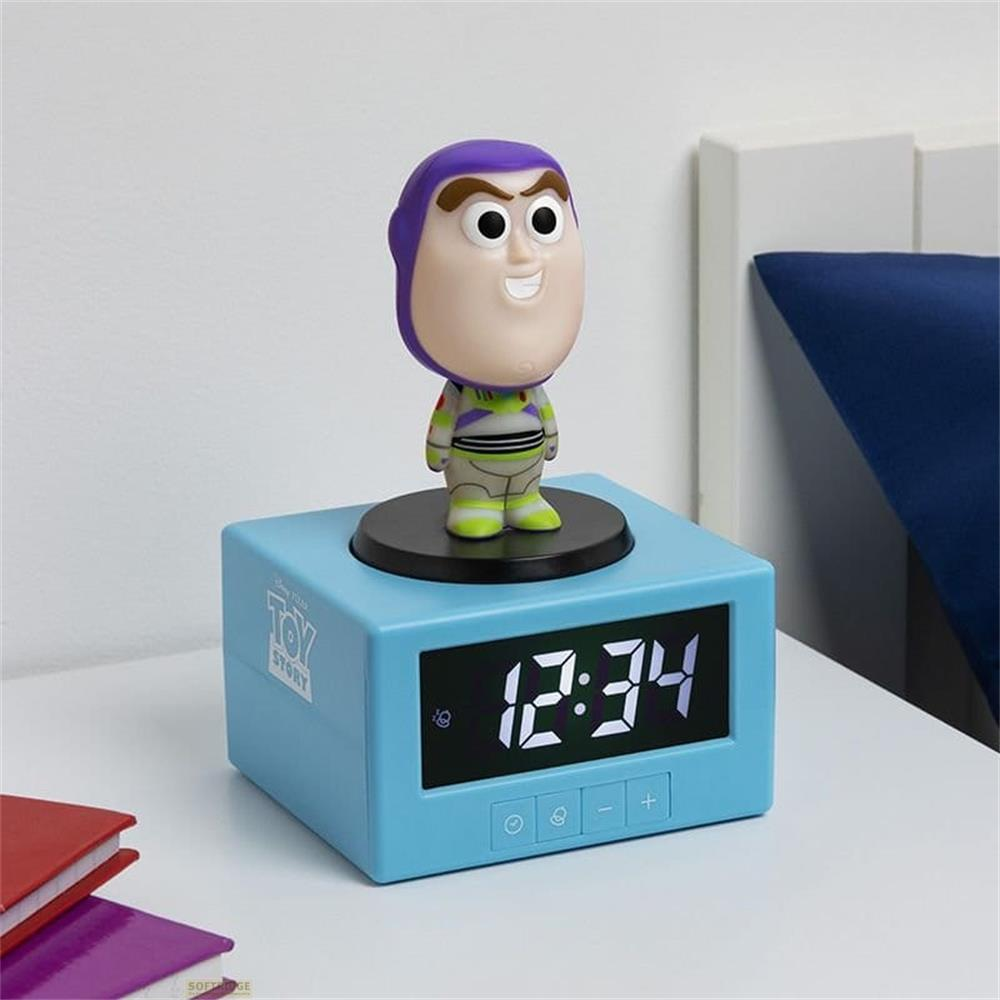 Figurka Buzza Astrala na niebieskim budziku z cyfrowym zegarem 12:34.