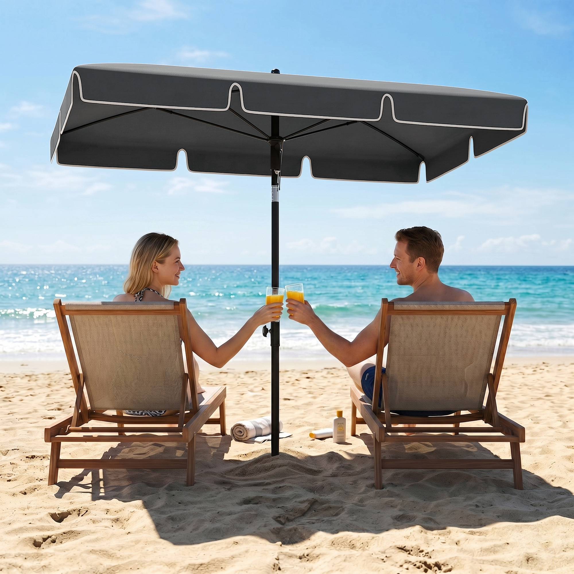 Una pareja brindando con bebidas en la playa bajo una sombrilla.