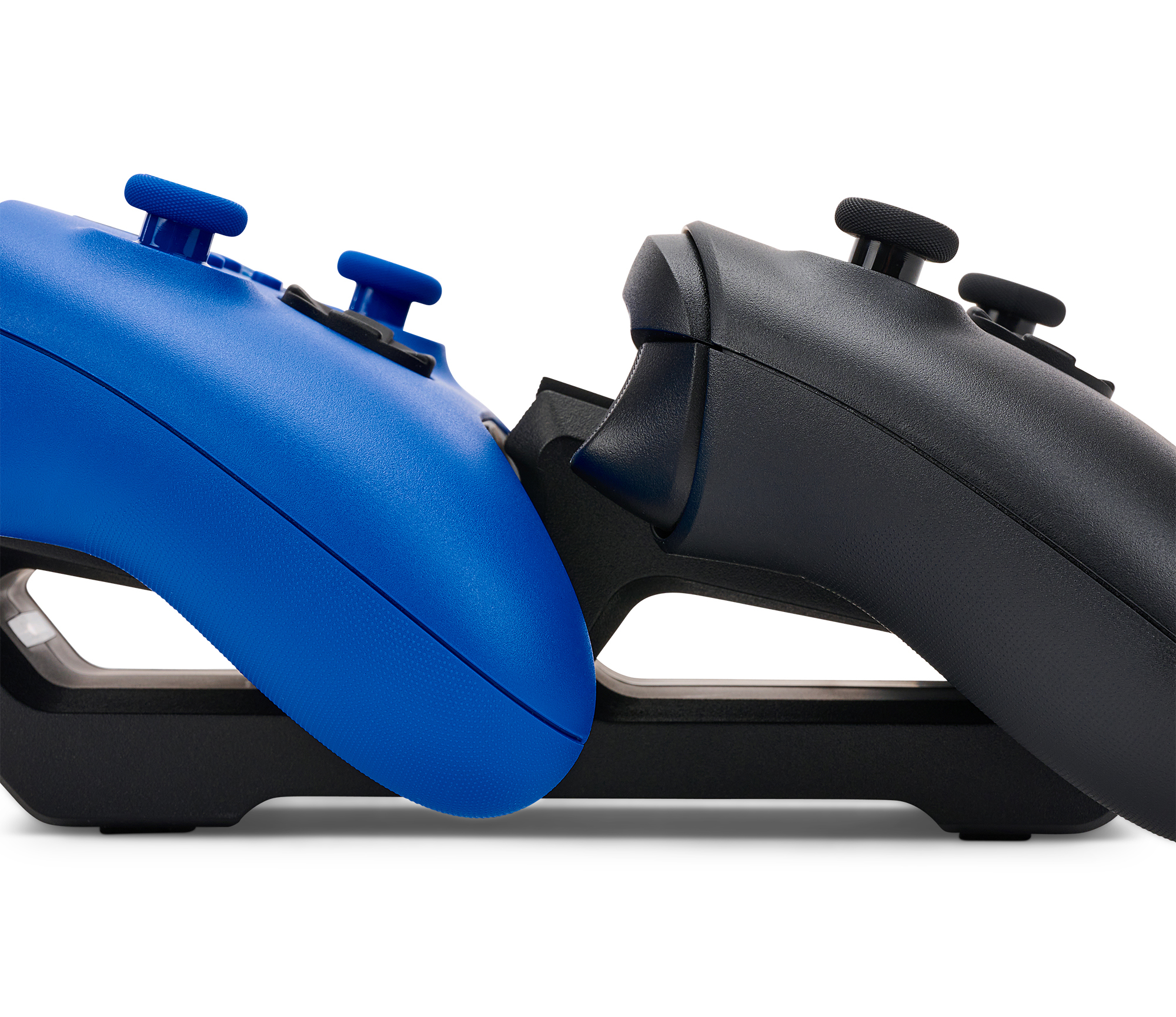 Ein blauer und ein schwarzer Controller liegen auf einer Ladestation.