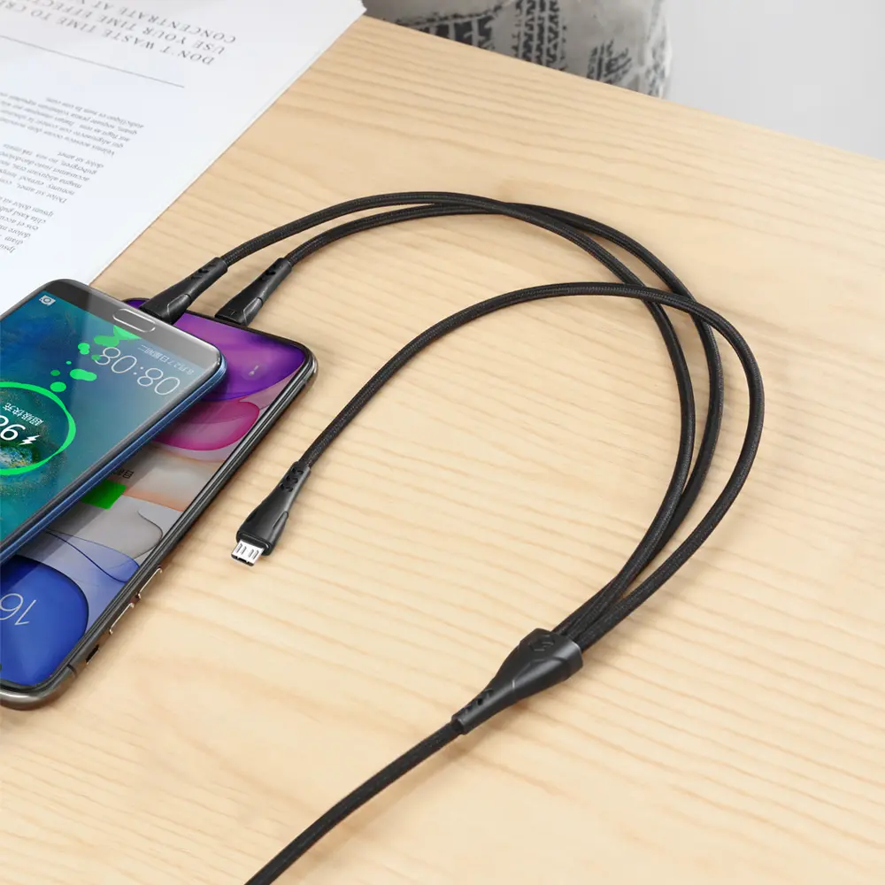 İki akıllı telefon, bölünen siyah bir kabloyla şarj oluyor.