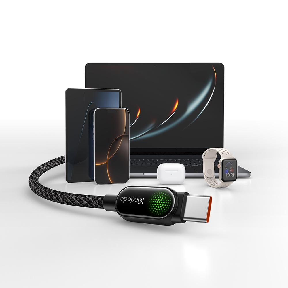 Yeşil ışıklı siyah USB-C kablosu, dizüstü bilgisayar, tablet, telefon, kulaklık ve saat yanında.
