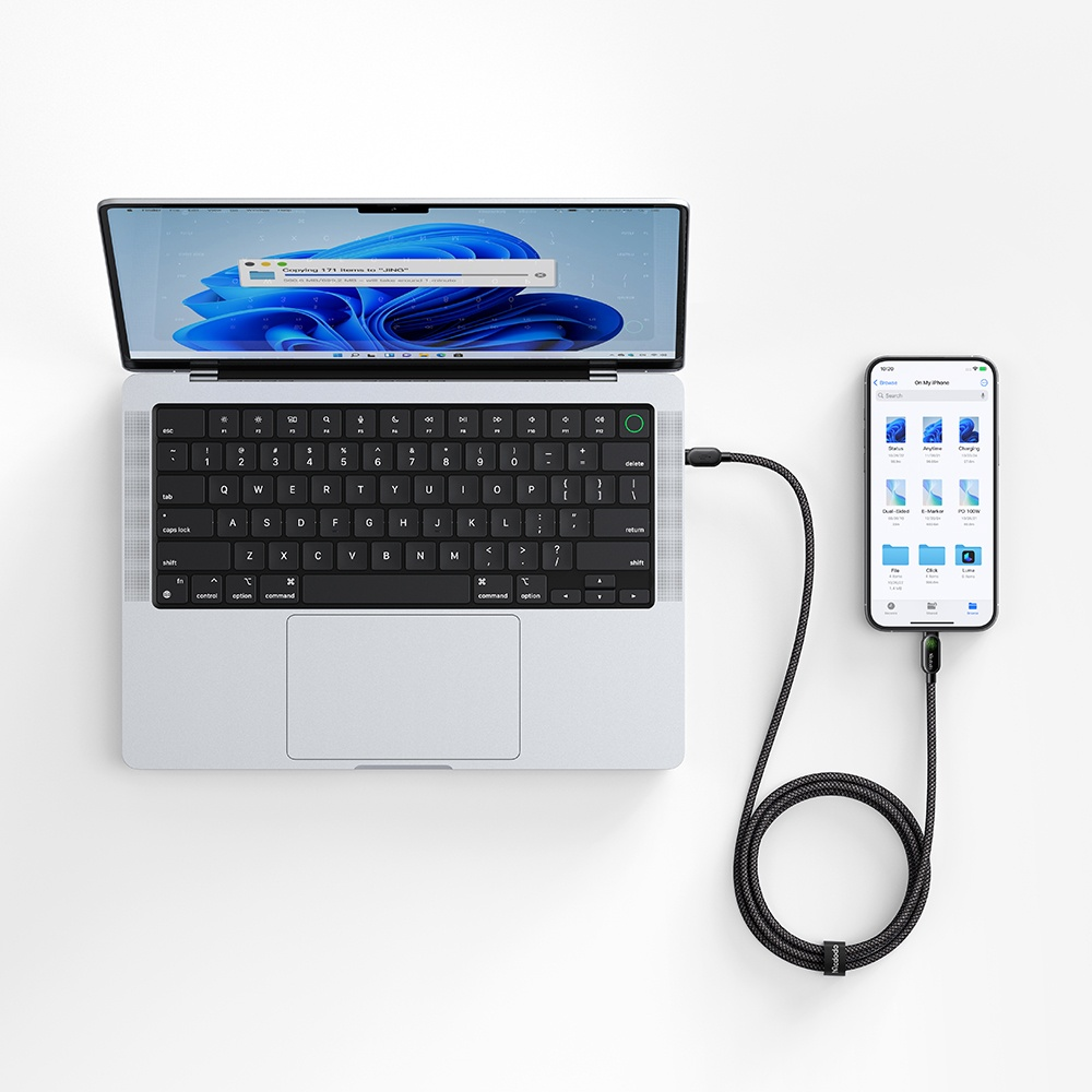 Siyah kabloyla birbirine bağlı bir dizüstü bilgisayar ve akıllı telefon.