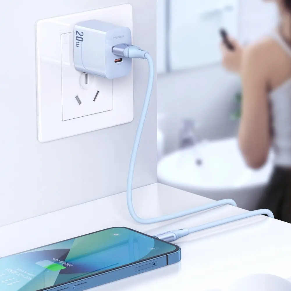 Açık mavi şarj kablosu bir akıllı telefonu 20W adaptöre bağlıyor.