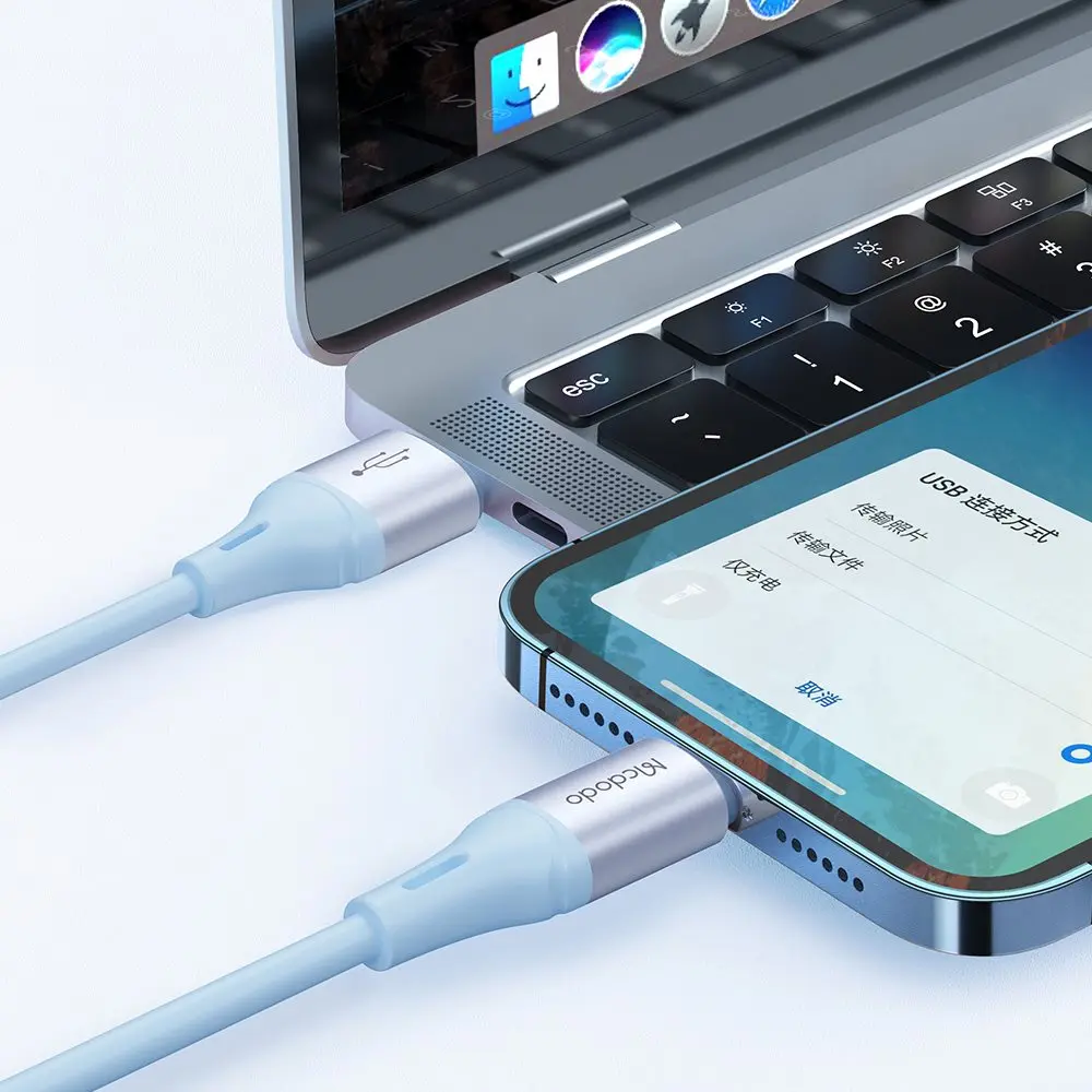Açık mavi USB kablosu bir akıllı telefonu bir dizüstü bilgisayara bağlıyor.