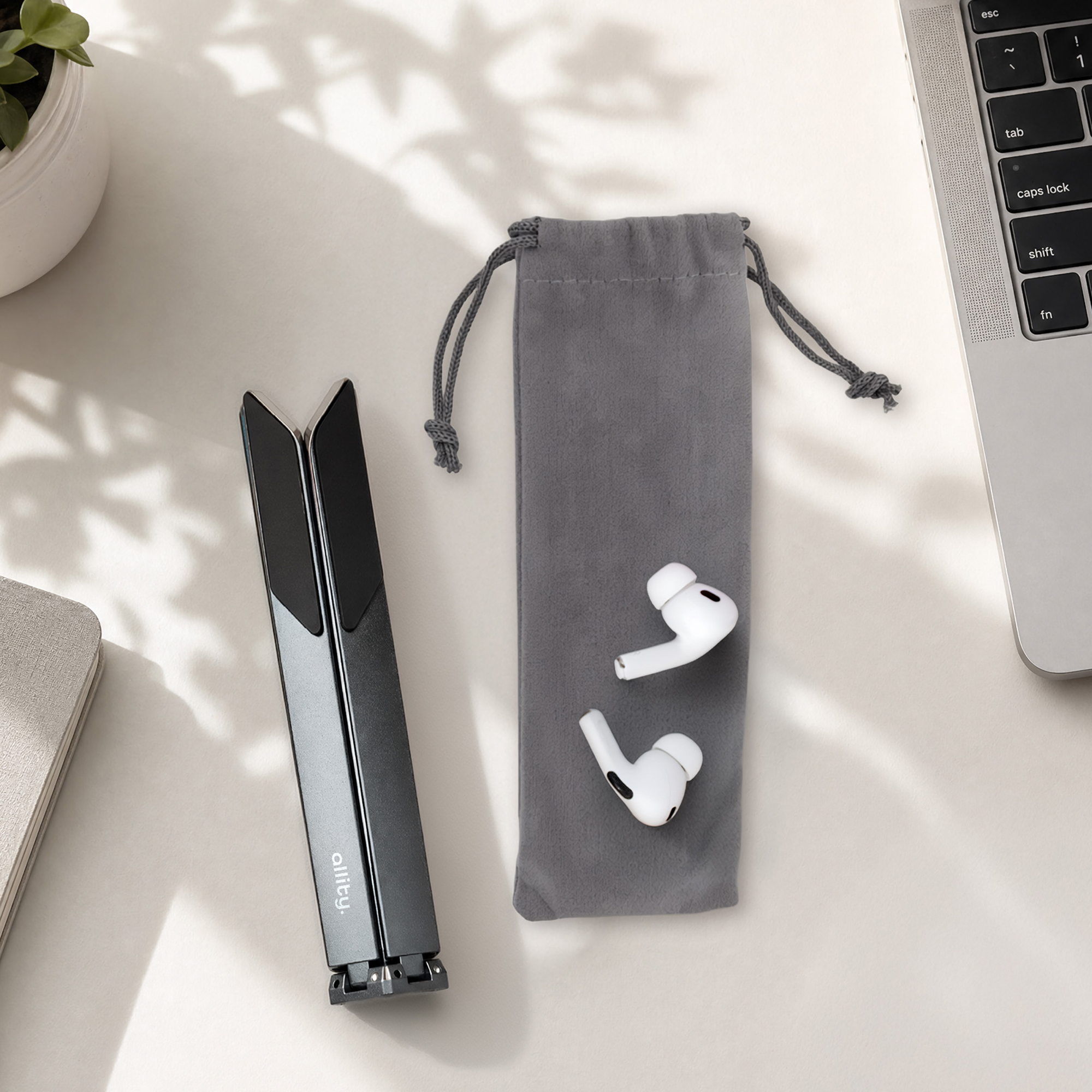 Składany stojak na laptopa, słuchawki i laptop na stole.