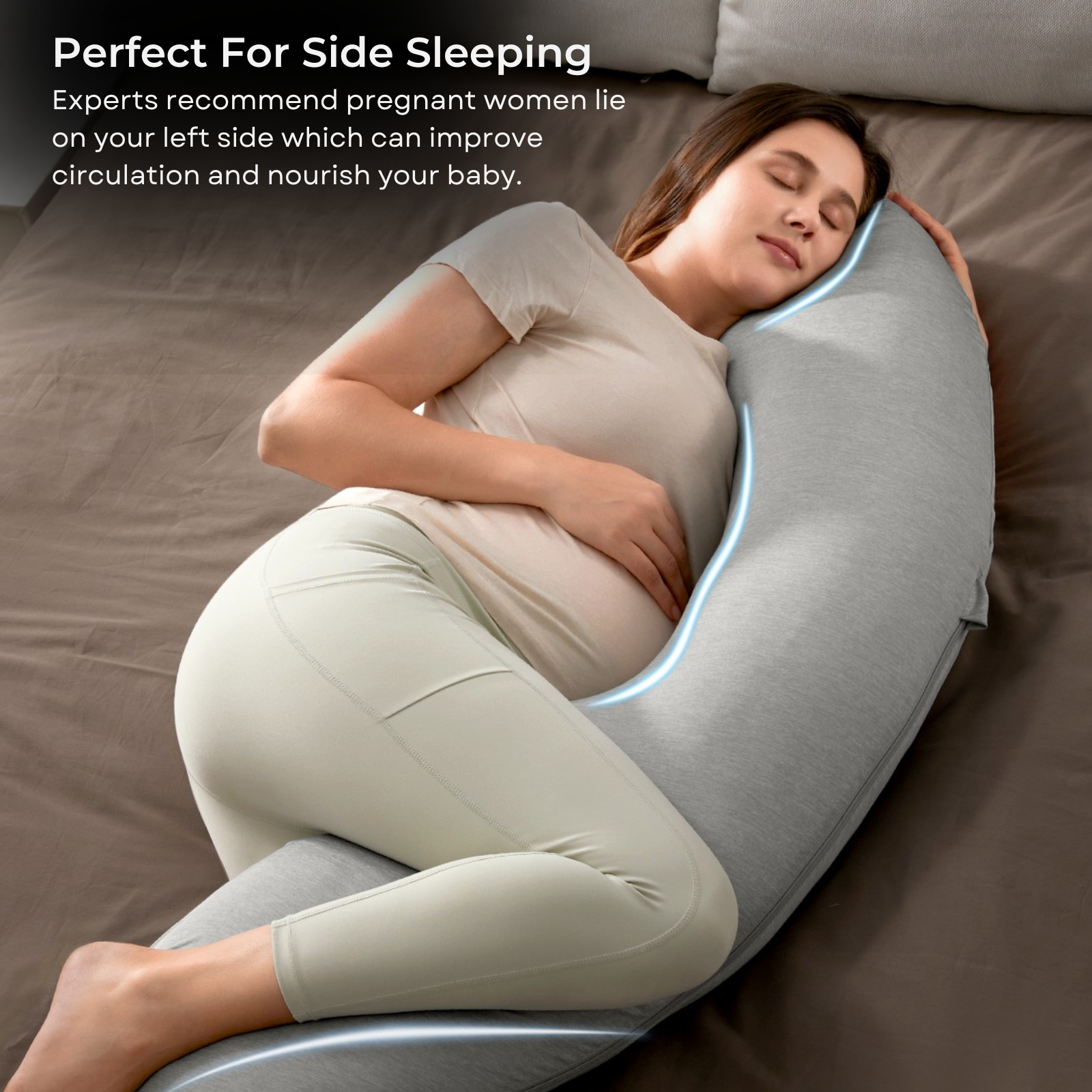 Une femme enceinte dort sur un coussin gris dans un lit marron.