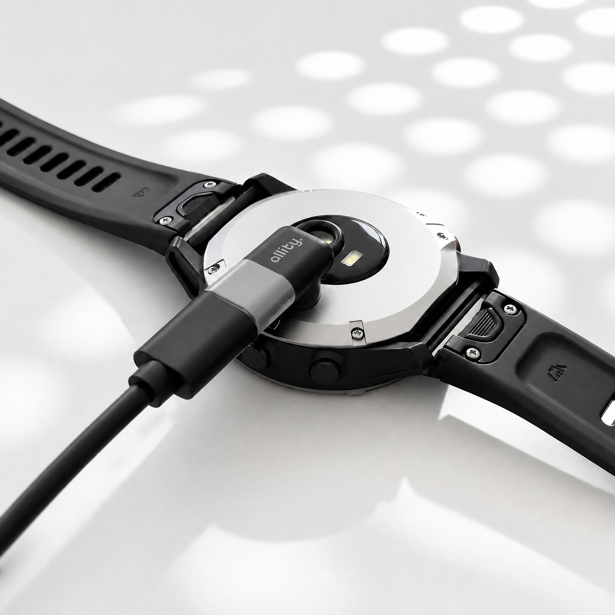 Czarny kabel ładujący smartwatch jest podłączony do tyłu smartwatcha.