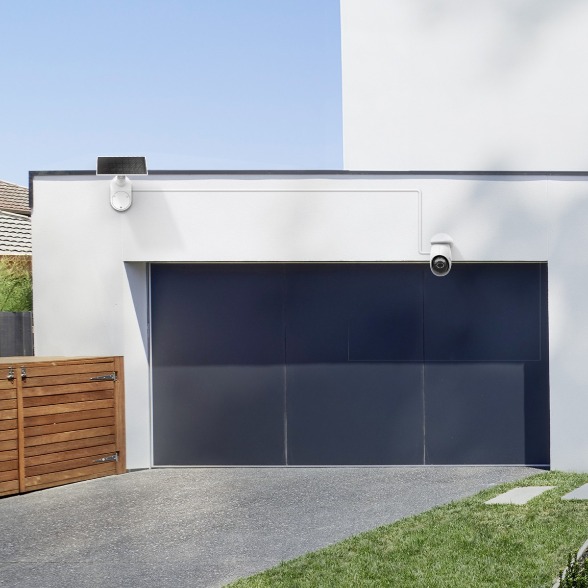 Garaje cubierto con puerta oscura, cámaras y panel solar.