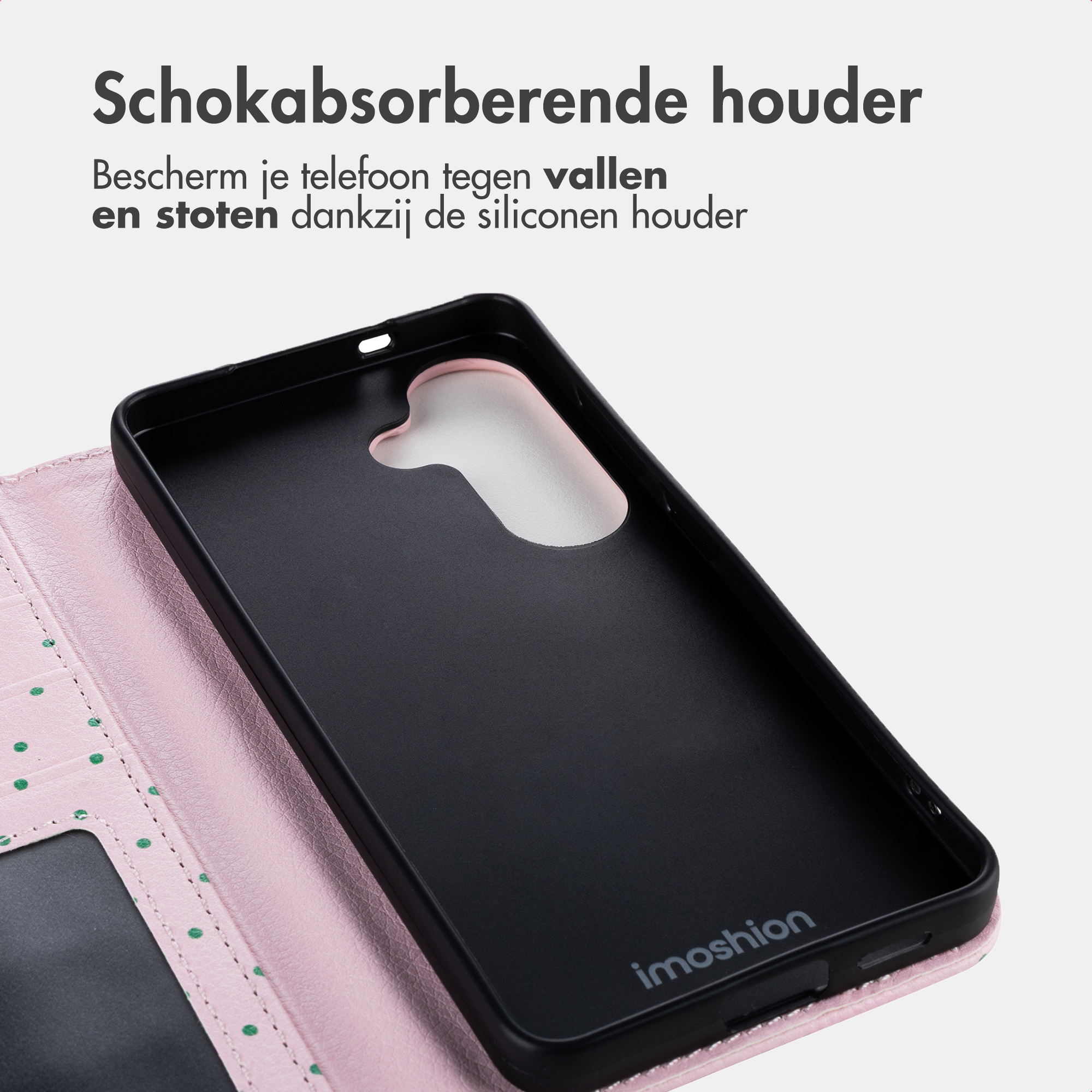 Een roze telefoonhoes met groene stippen en een zwart interieur.