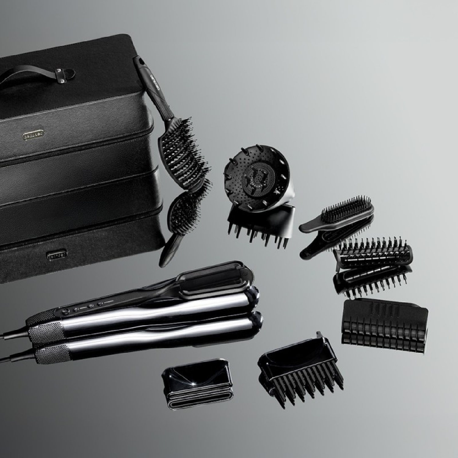 Set nero per lo styling dei capelli con custodia, piastra, diffusore e varie spazzole.