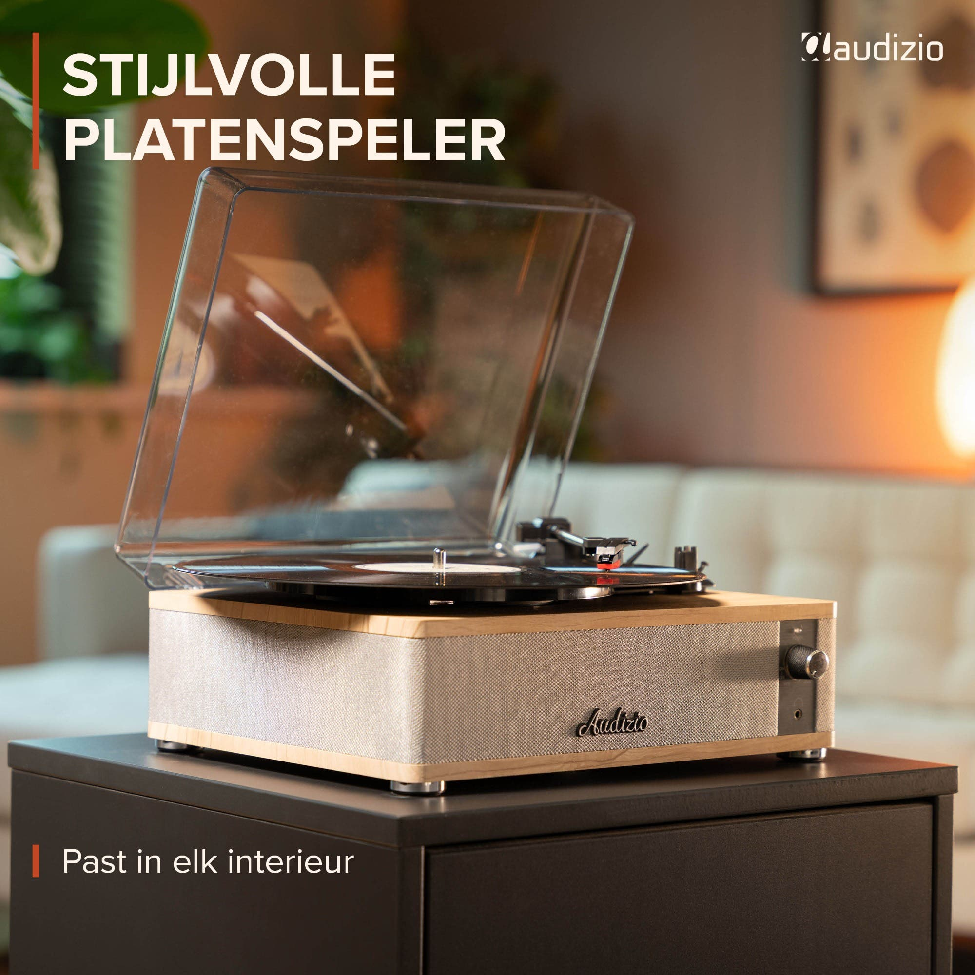 Un tocadiscos con marco de madera y tapa transparente sobre un mueble oscuro.