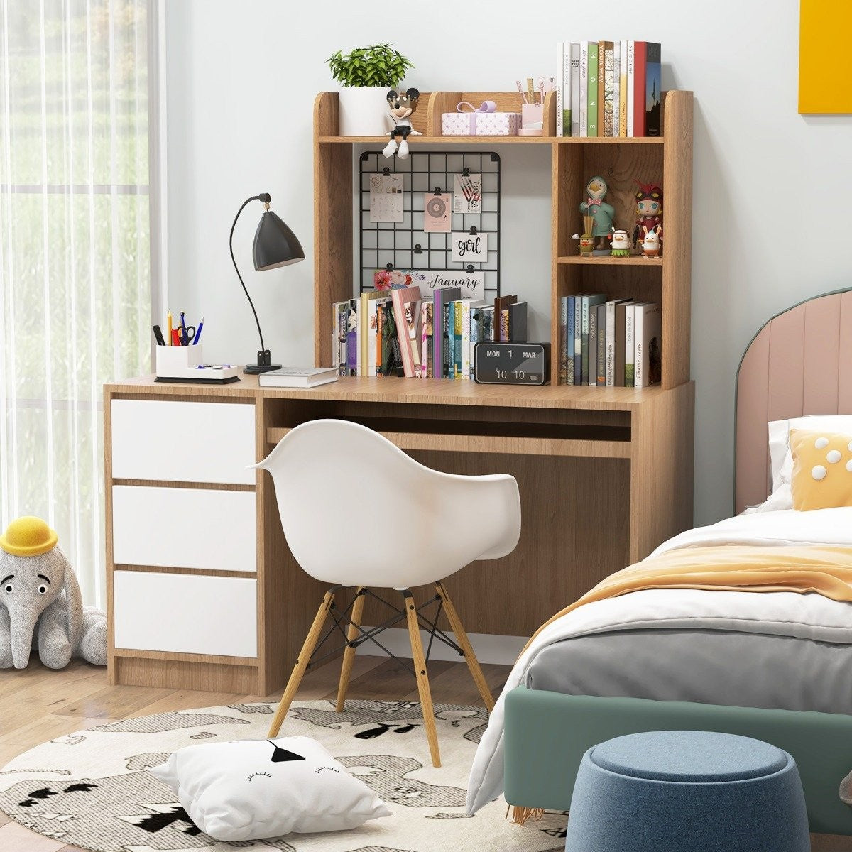 Bureau van een kind met witte stoel, boeken en decoraties. Een bed is in de buurt.