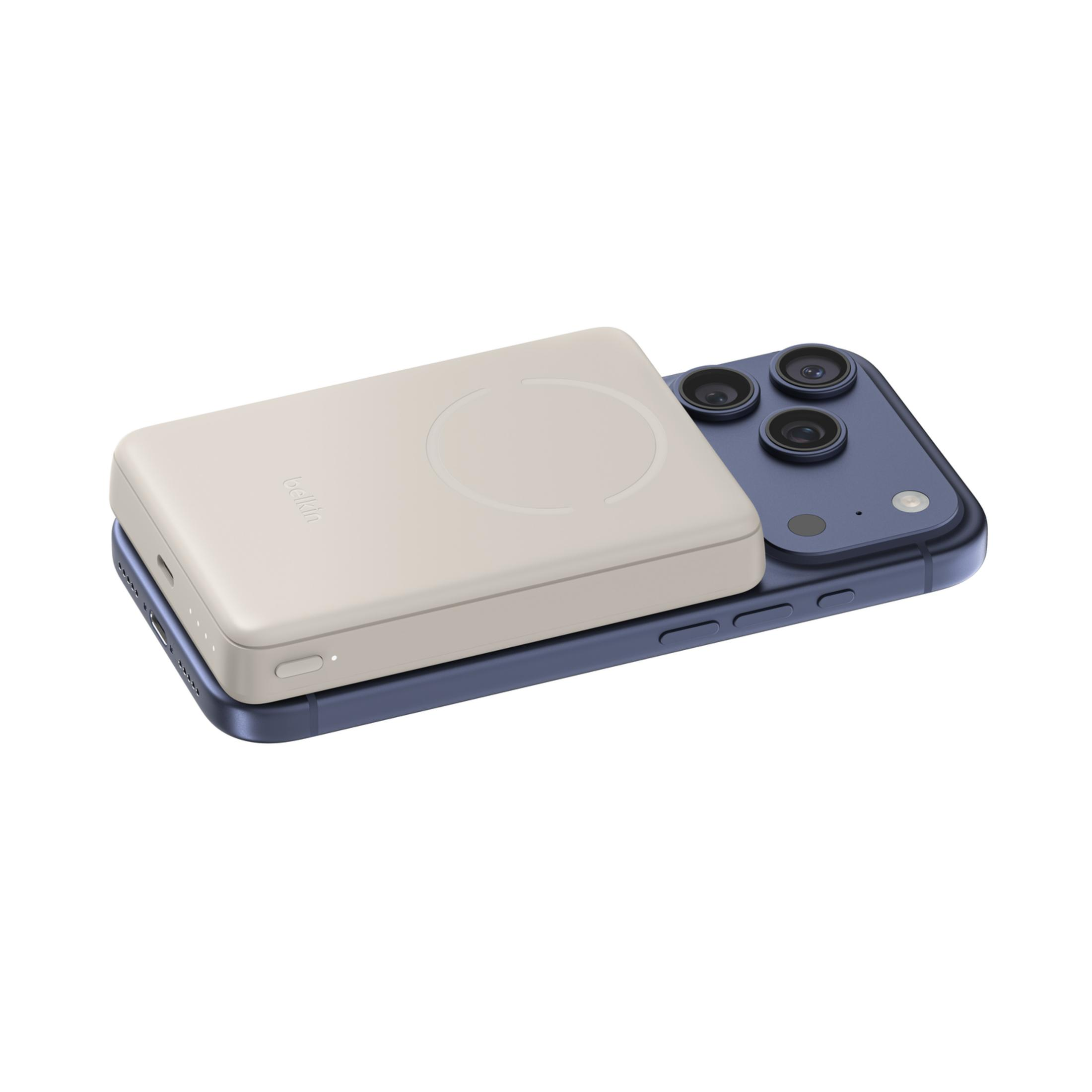 Un power bank beige poggia su uno smartphone blu con tre fotocamere.