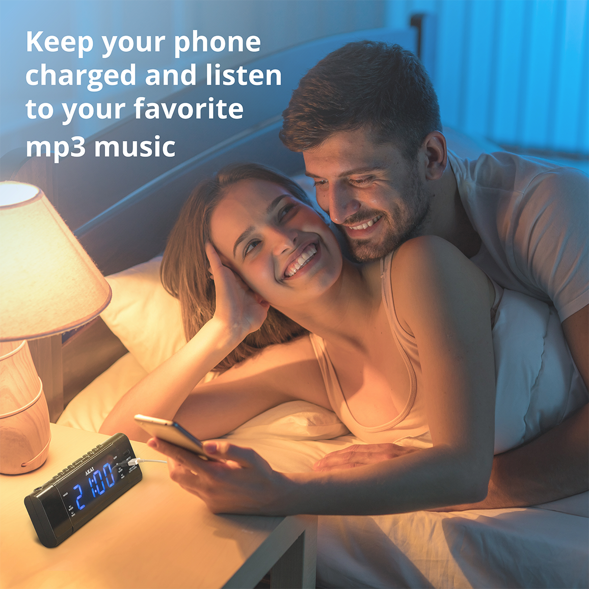 Para w łóżku, kobieta trzyma telefon, mężczyzna ją przytula.