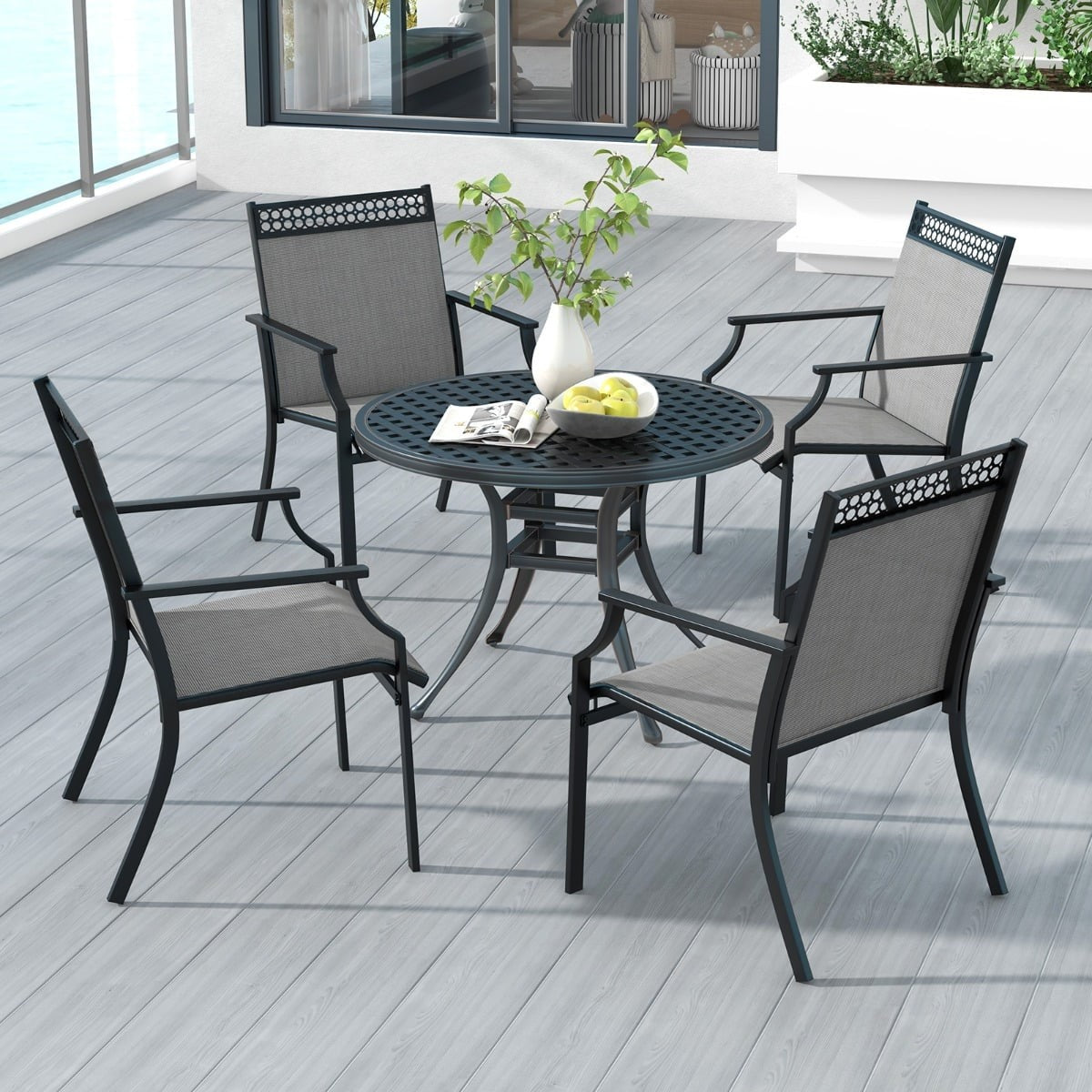 Een ronde tafel met vier stoelen op een houten terras.