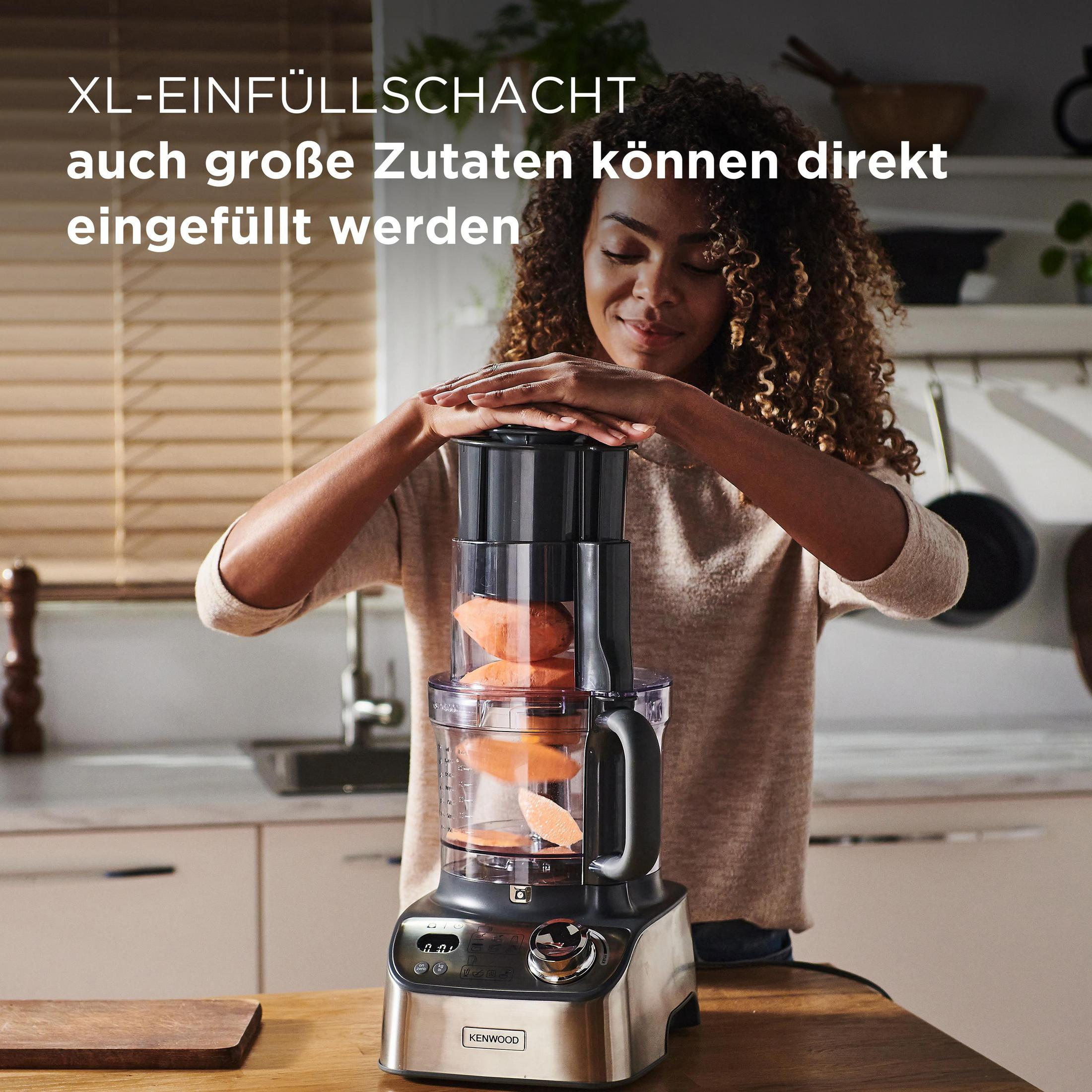 Eine Frau mit lockigem Haar bedient einen Kenwood Food Processor mit Süßkartoffeln darin.