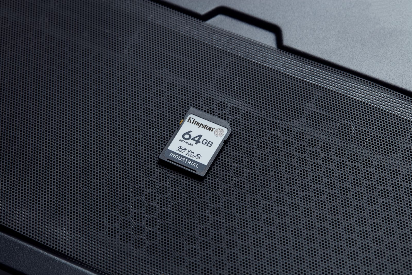 Eine Kingston 64GB industrielle SD-Karte liegt auf einem perforierten Gitter.