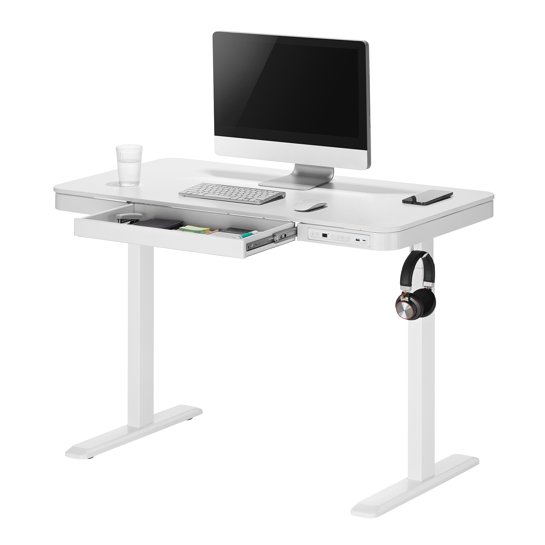 Una scrivania bianca con monitor, tastiera, mouse, bicchiere d'acqua, cuffie e cassetto.