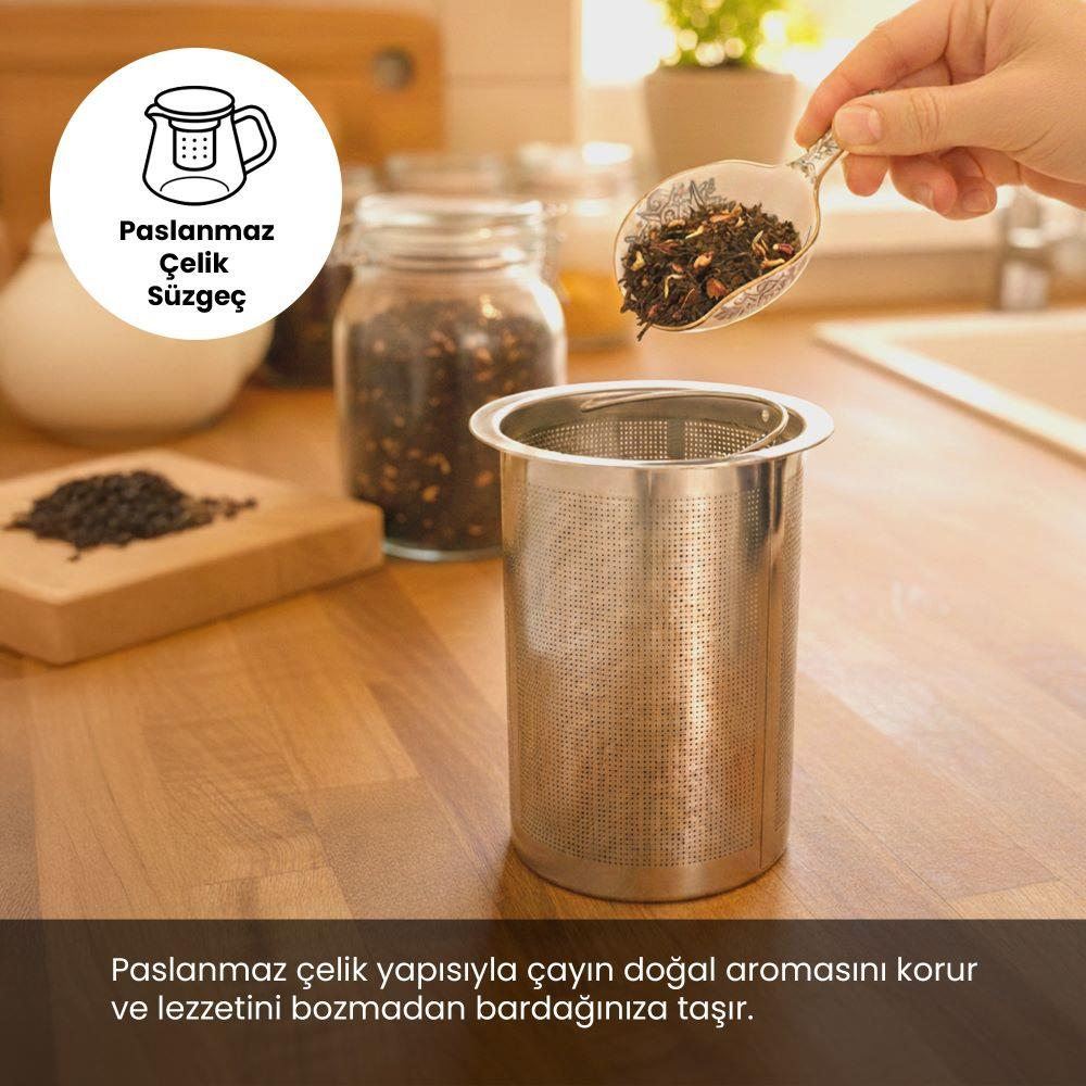 Bir el metal süzgece çay ekliyor. Arka planda kavanozlar ve ahşap.