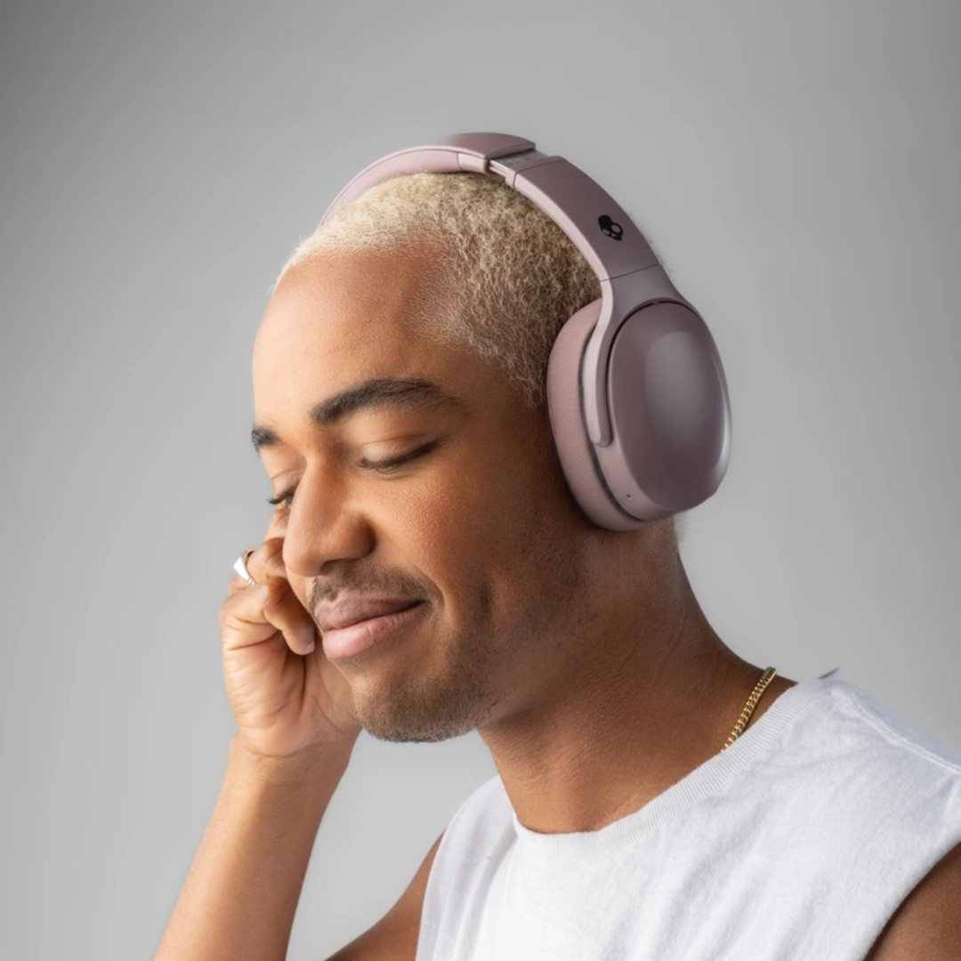 Sarışın saçlı bir adam müzik dinlerken kulaklık takıyor.