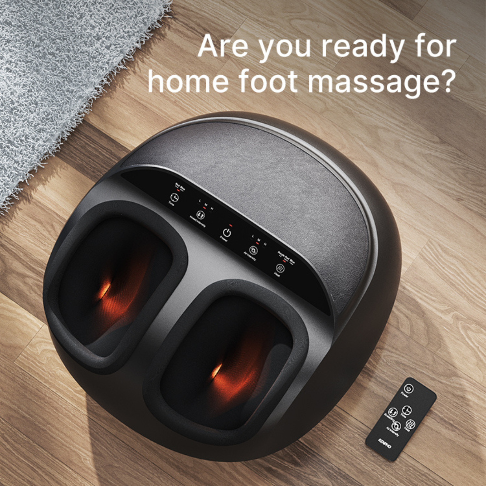 A black foot massager with remote control on a wooden floor.