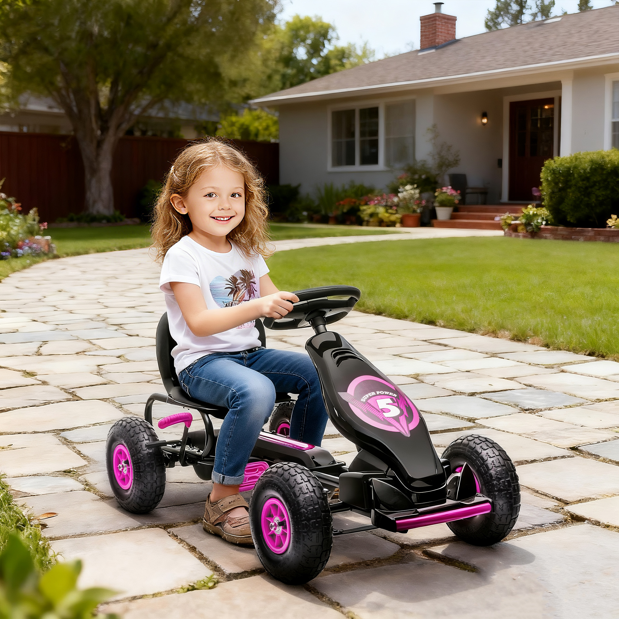 Una niña sonríe mientras conduce un go-kart negro con detalles rosas en un camino pavimentado.