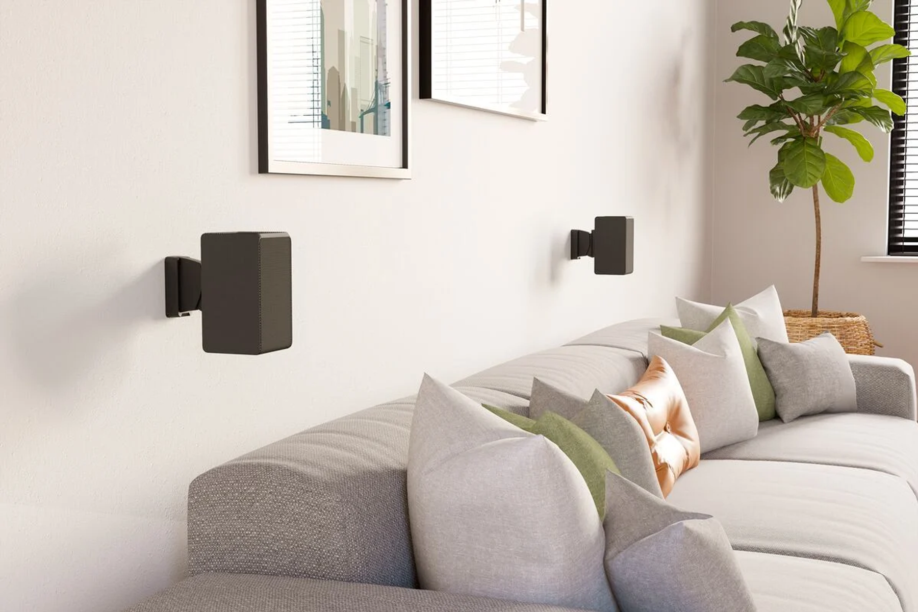 Zwei schwarze Lautsprecher an der Wand montiert über einem Sofa mit Kissen.