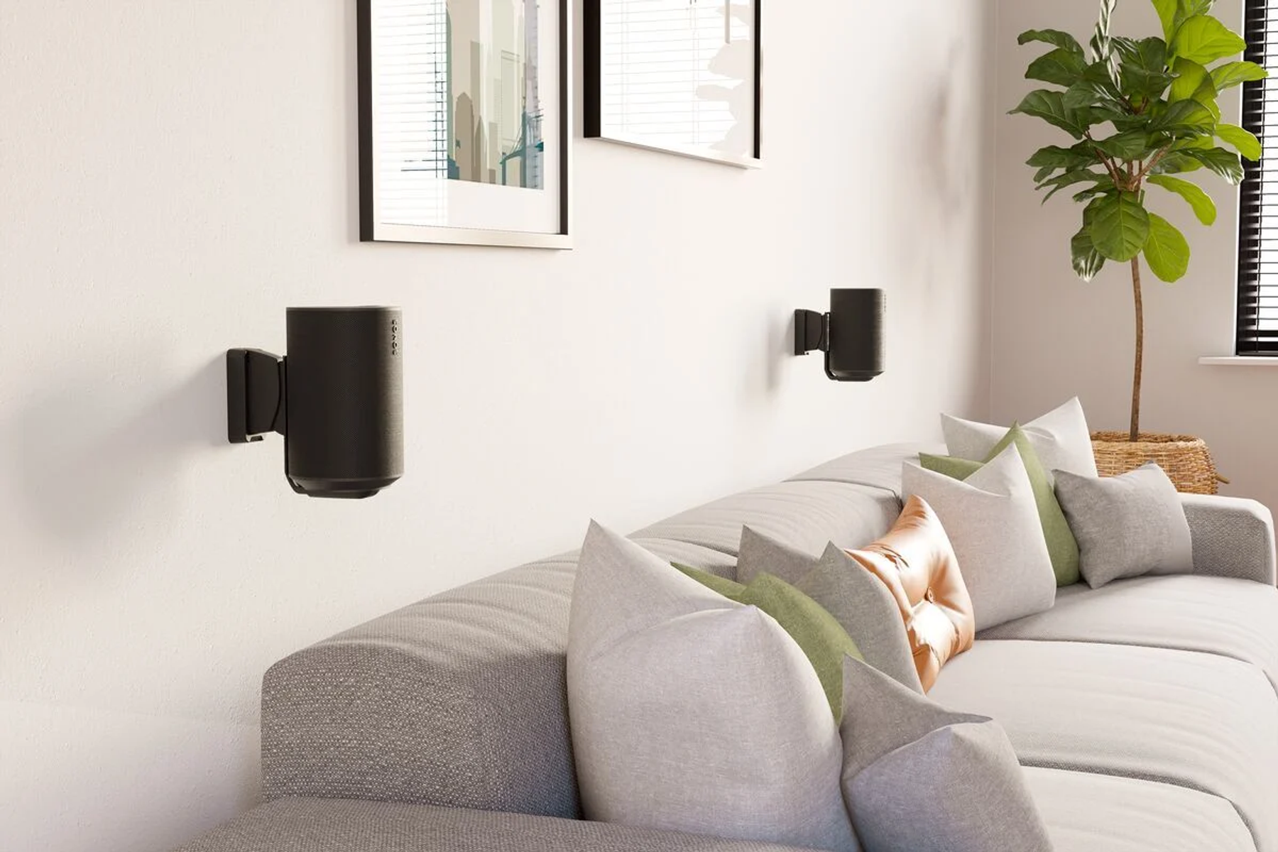Zwei schwarze Wandlautsprecher über einem Sofa mit Kissen. Ein Bild an der Wand.