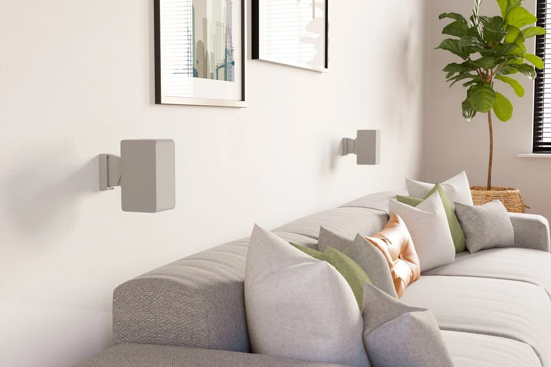 Graue Lautsprecher an weißer Wand über Sofa mit Kissen. Pflanze im Korb.