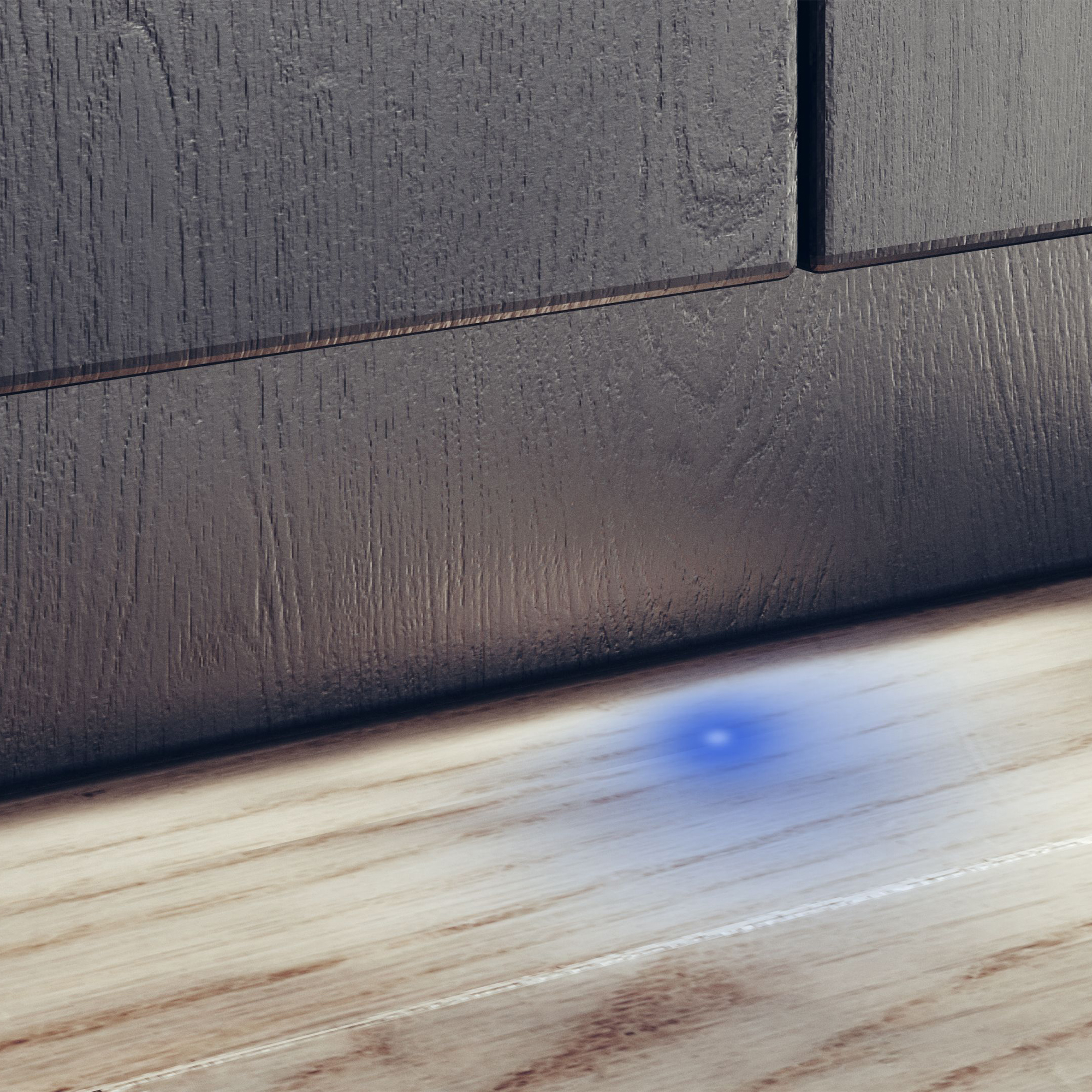 Holzschrank mit blauem Lichtpunkt auf hellem Holzboden.